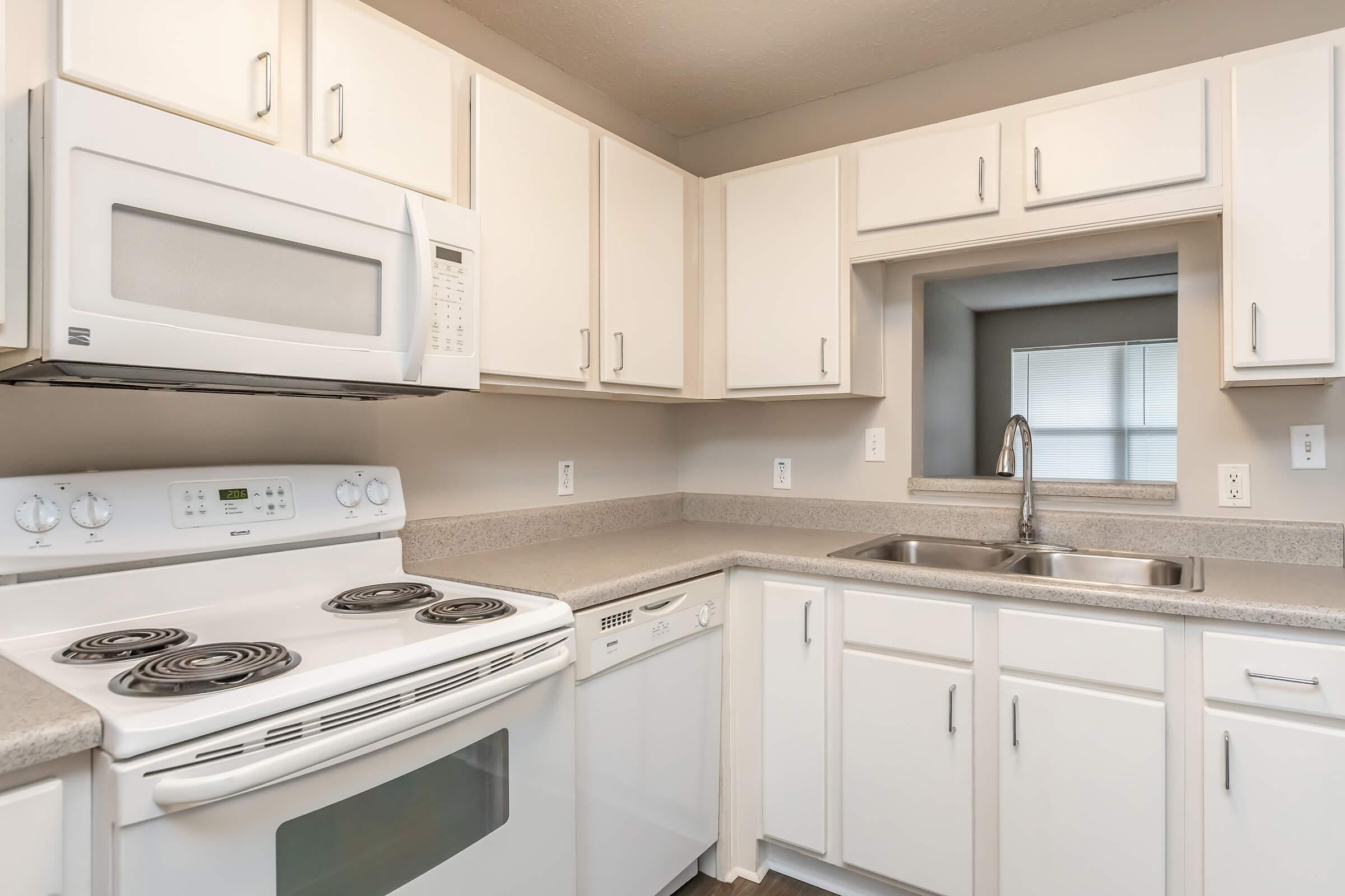 a kitchen with a stove a sink and a microwave