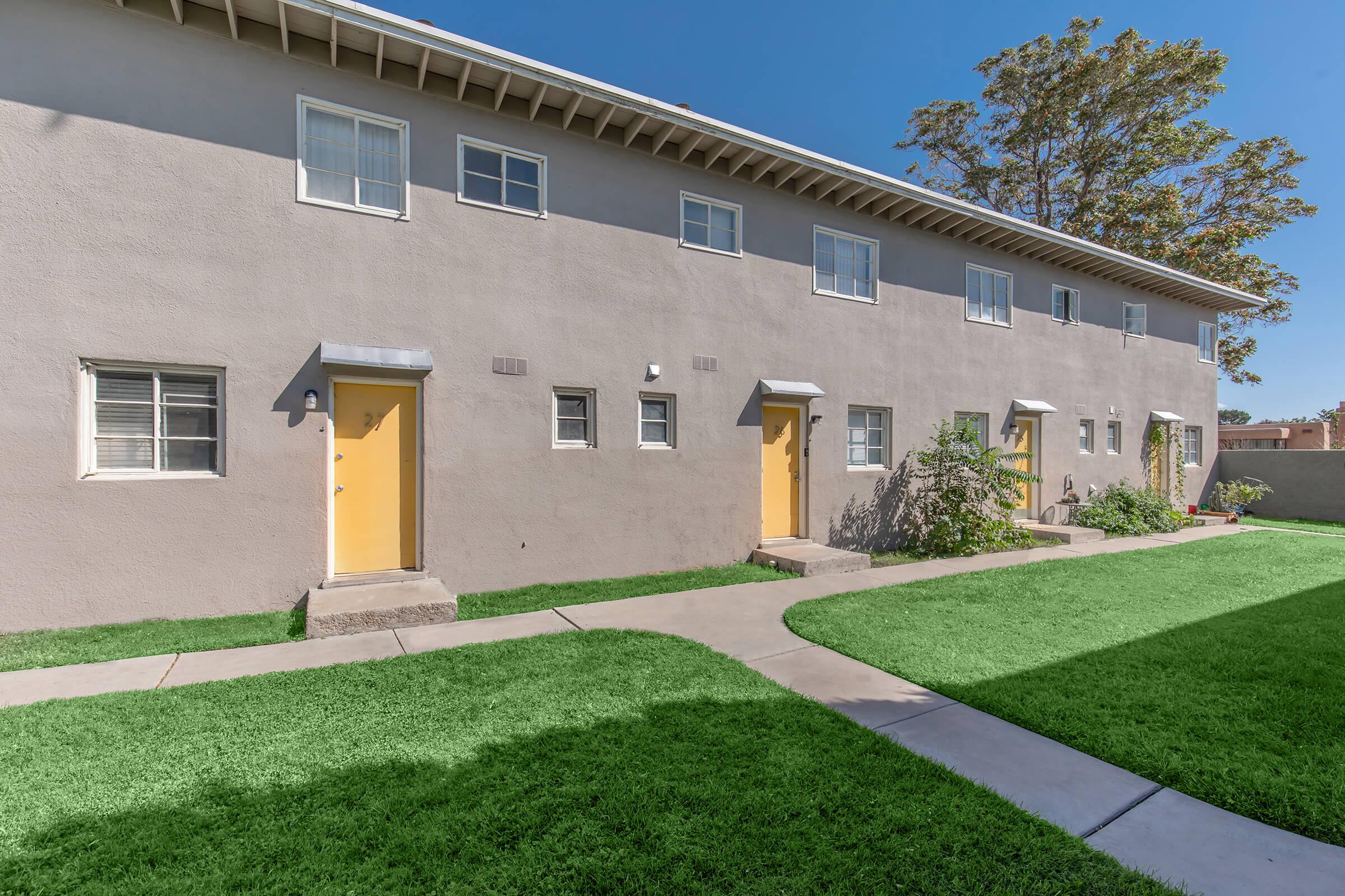 a large brick building with grass in front of a house