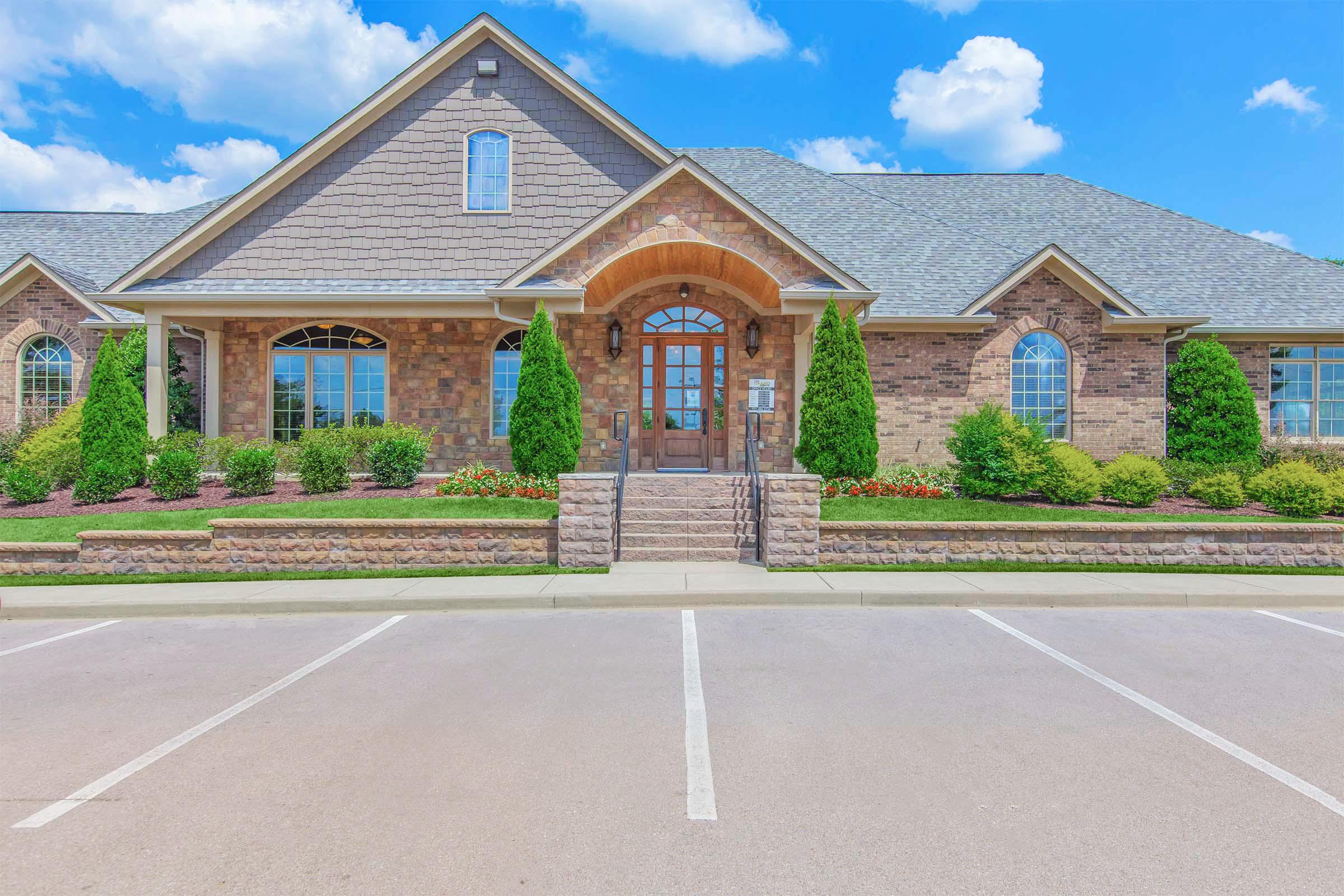 a large brick building with grass in front of a house