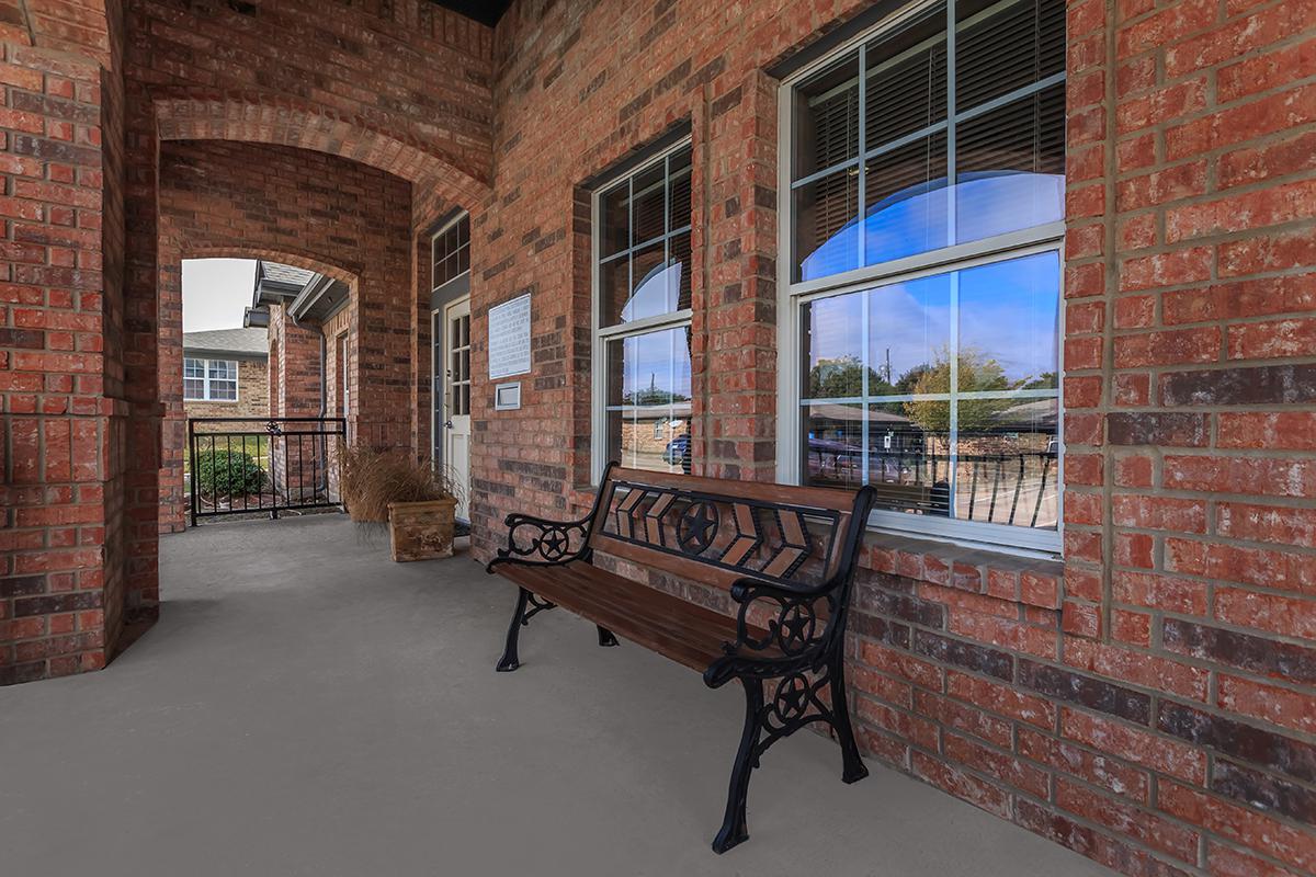 a bench in front of a brick building