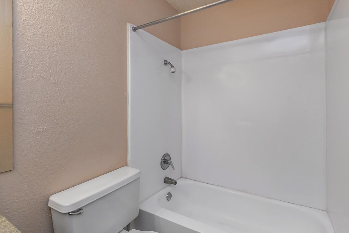 a white tub sitting next to a shower