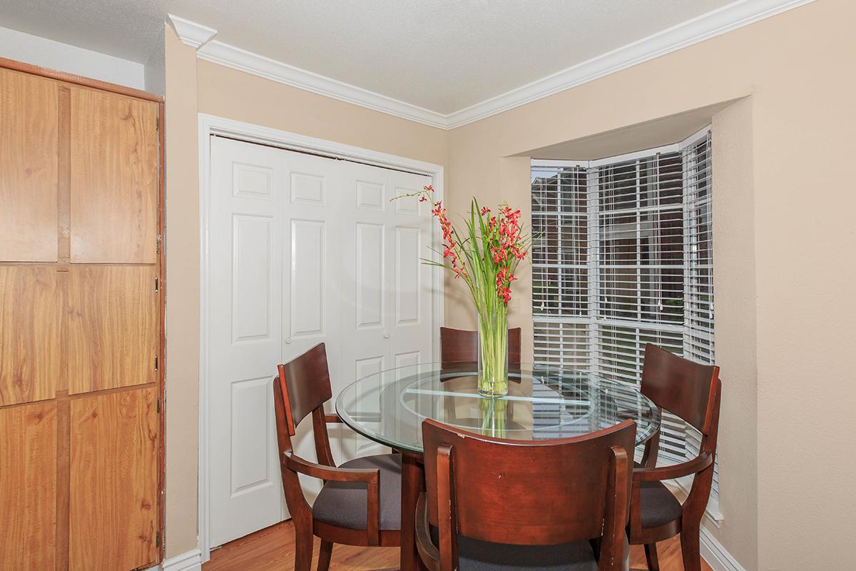 a room filled with furniture and vase of flowers on a table