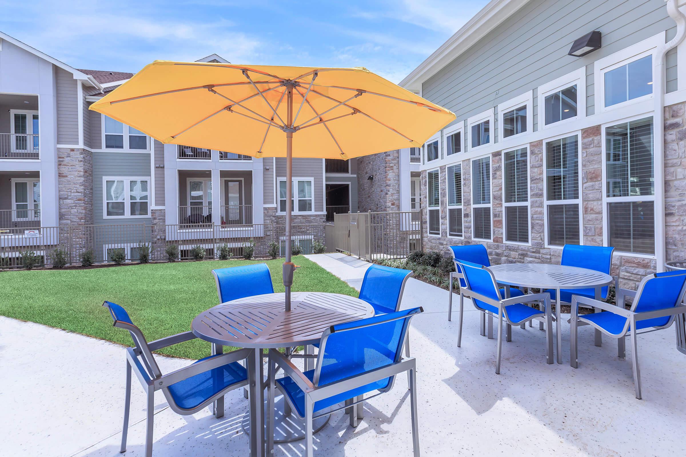 a group of lawn chairs sitting on a chair with a blue umbrella