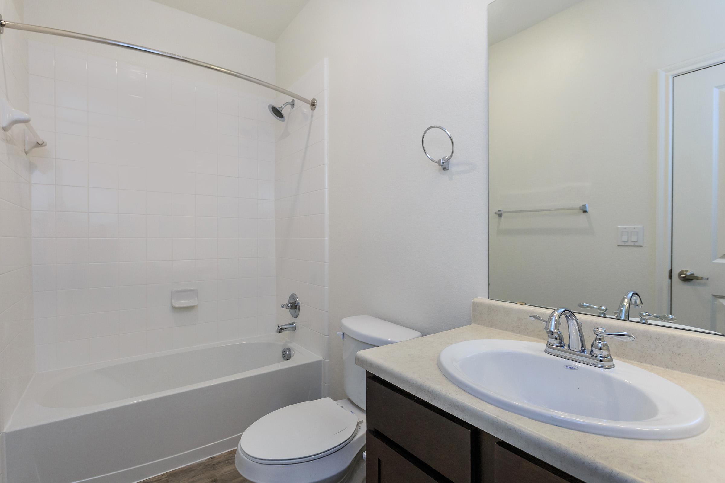 a white sink sitting under a mirror