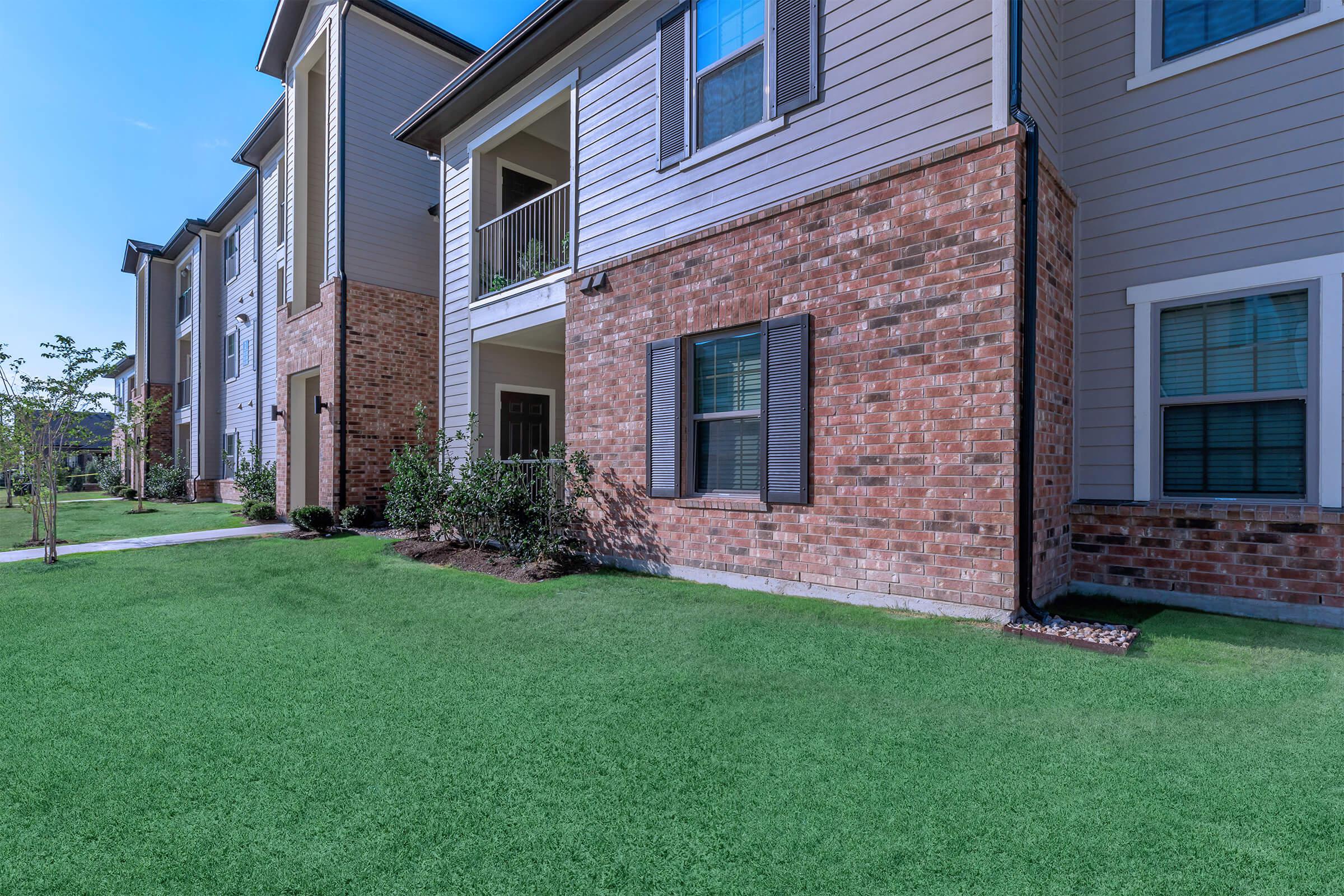 a large lawn in front of a brick building