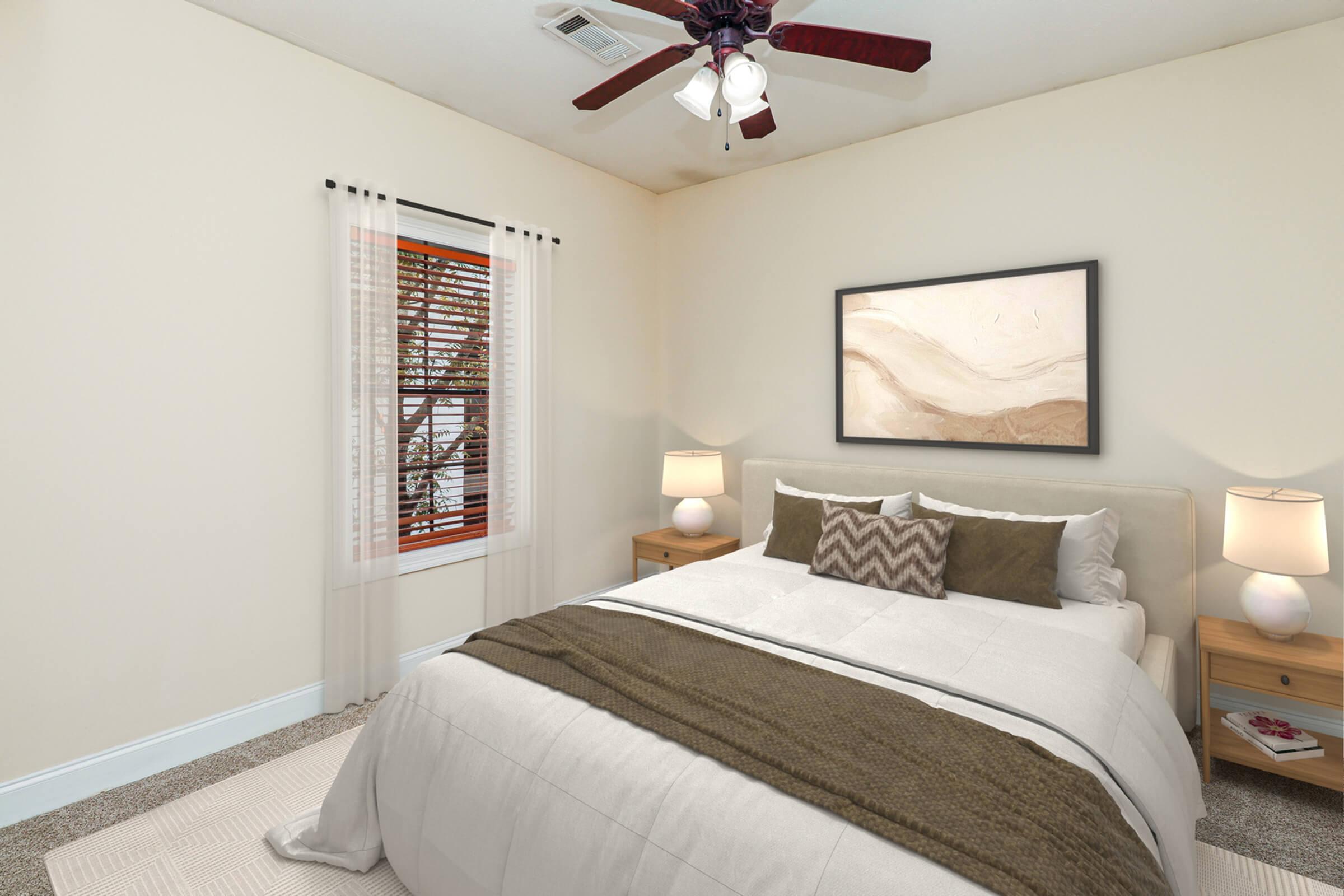 A cozy bedroom featuring a queen-sized bed with a light beige comforter, accented by brown pillows. Wooden nightstands with lamps on either side of the bed enhance the warm atmosphere. A large window with sheer curtains allows natural light to fill the room, and an abstract painting hangs above the bed.