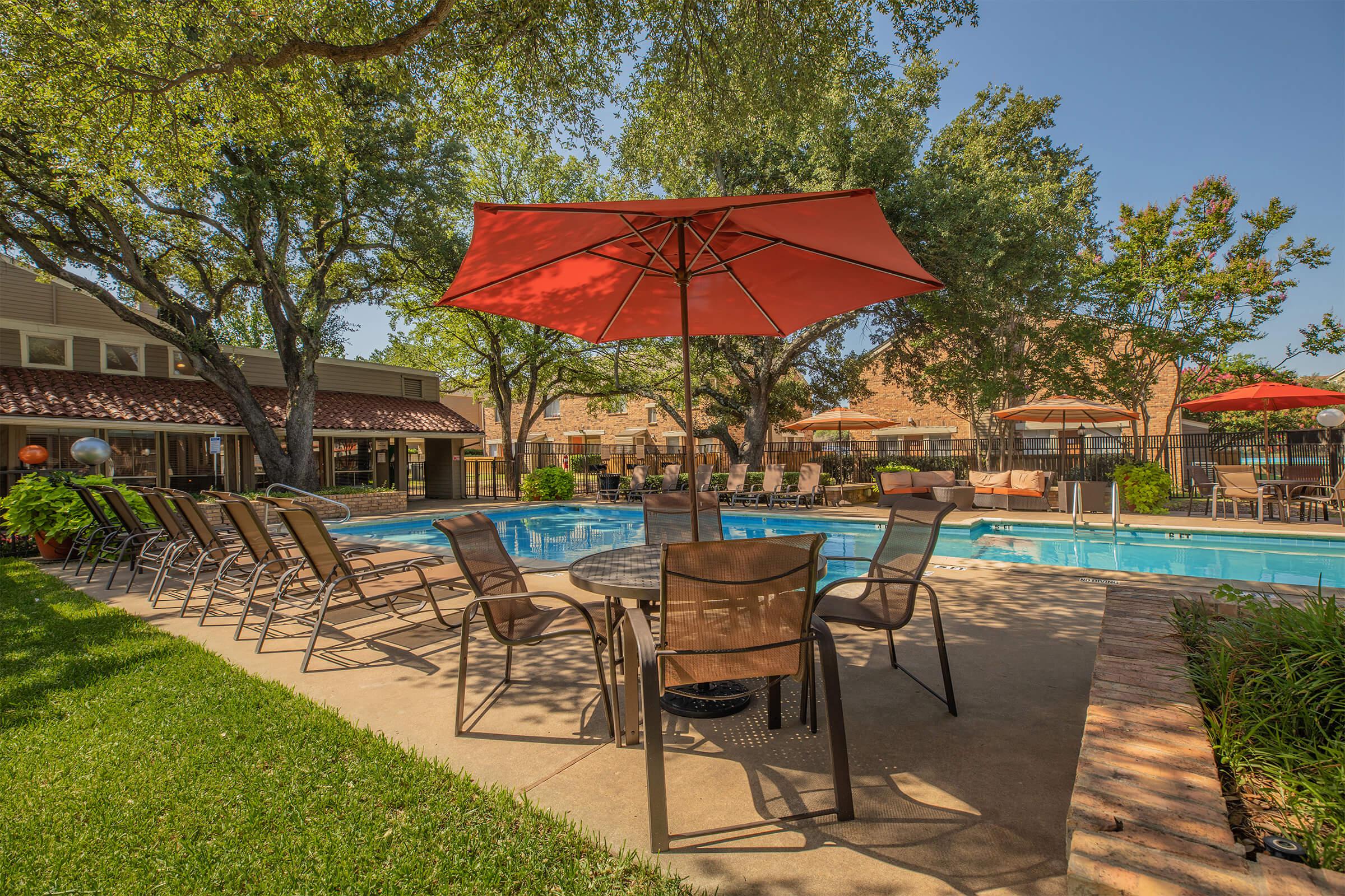 a group of lawn chairs under an umbrella