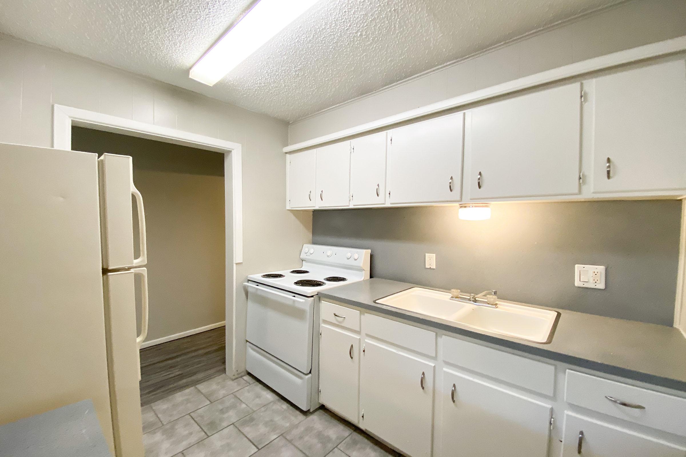 a kitchen with a stove sink and refrigerator