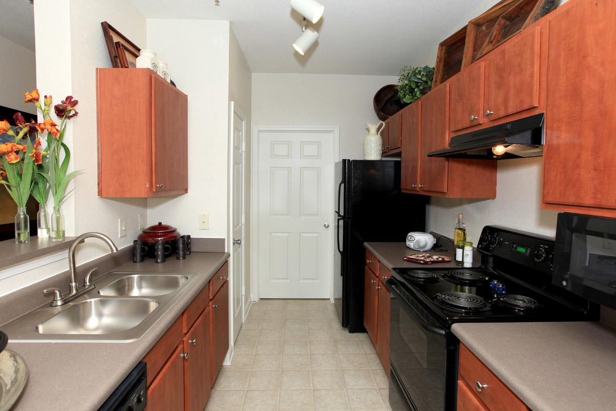 a modern kitchen with stainless steel appliances and wooden cabinets