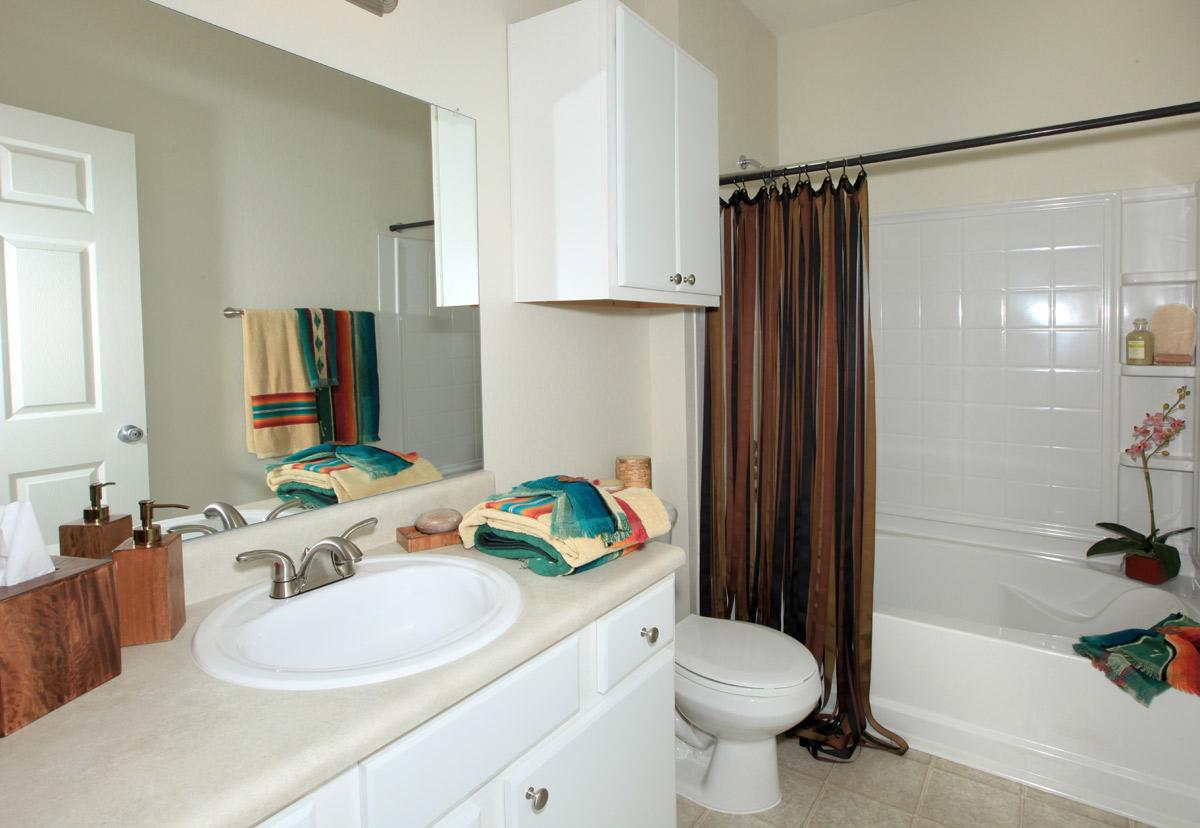 a bedroom area with a sink and a mirror