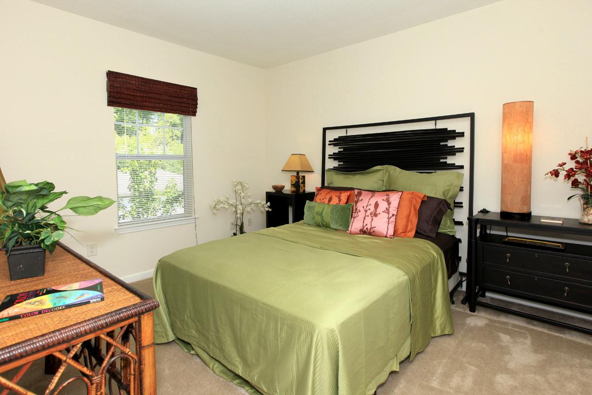 a bedroom with a bed and desk in a room