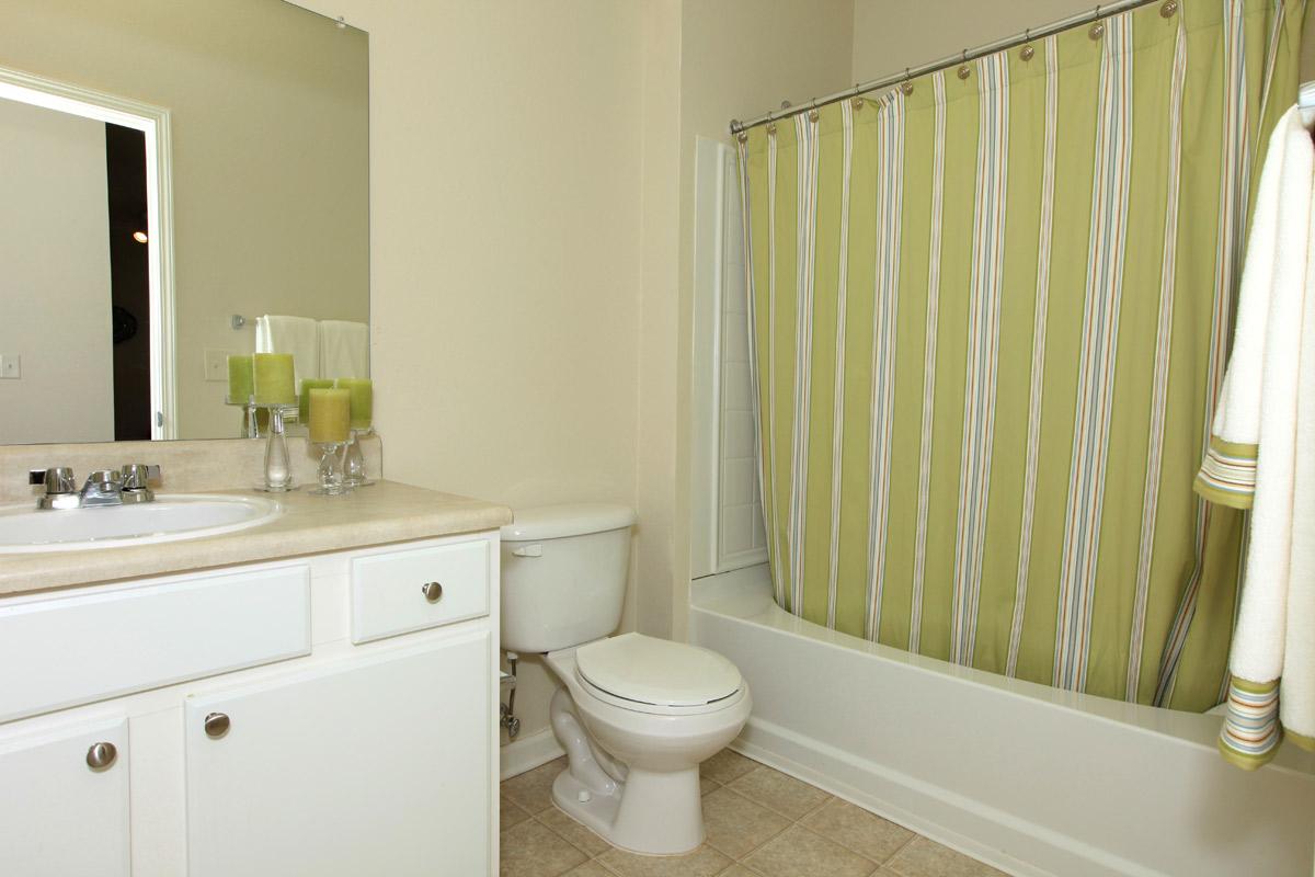 a white sink sitting next to a shower curtain