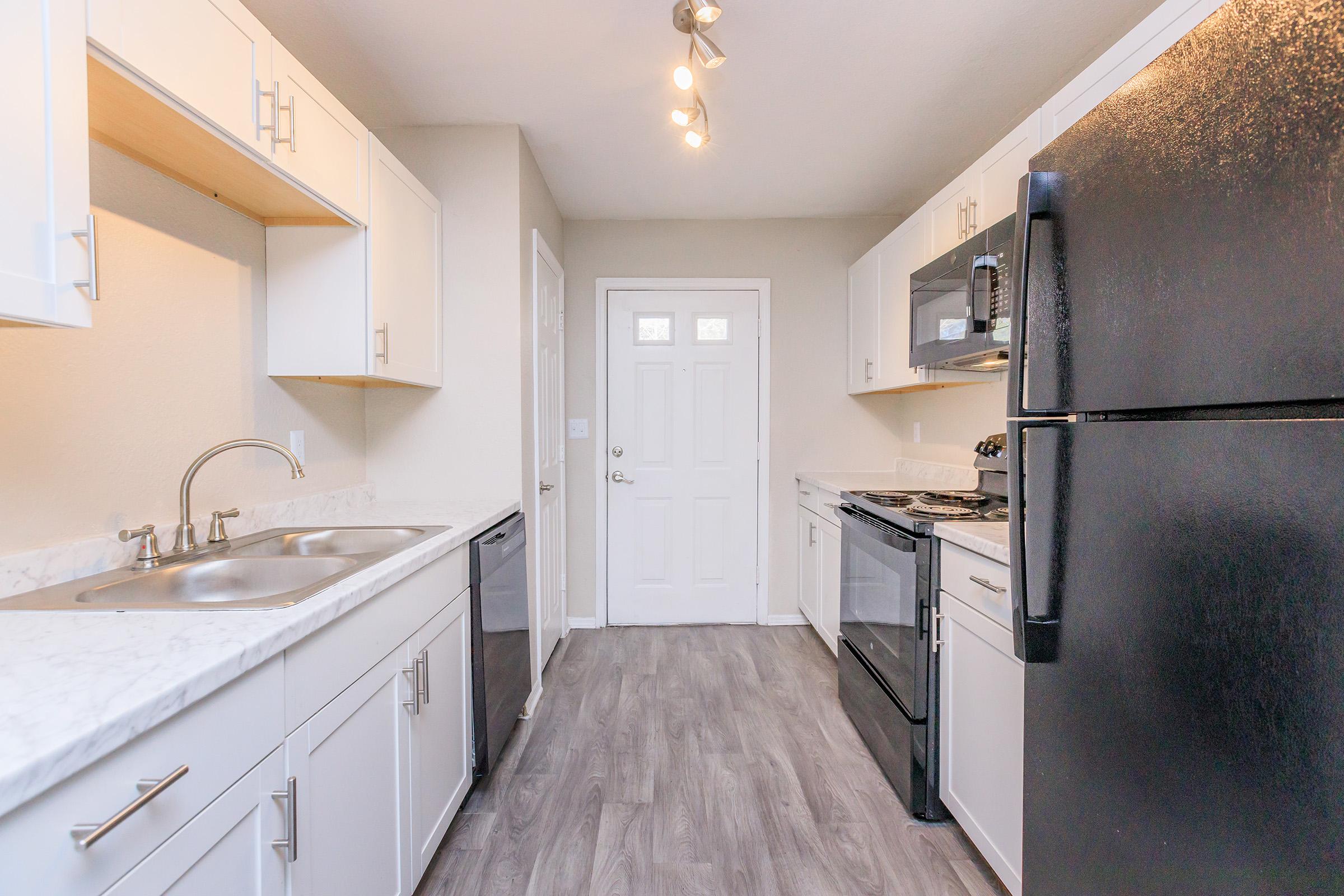 a kitchen with a sink and a refrigerator