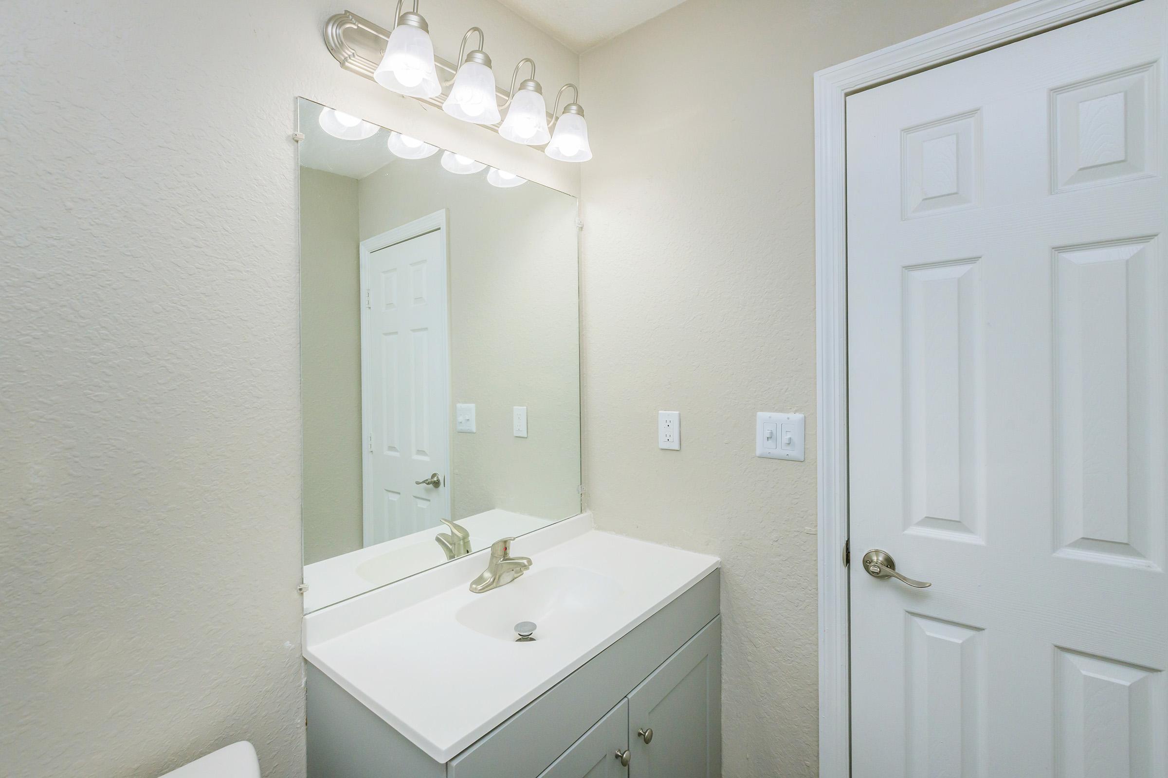 a room with a sink and a mirror