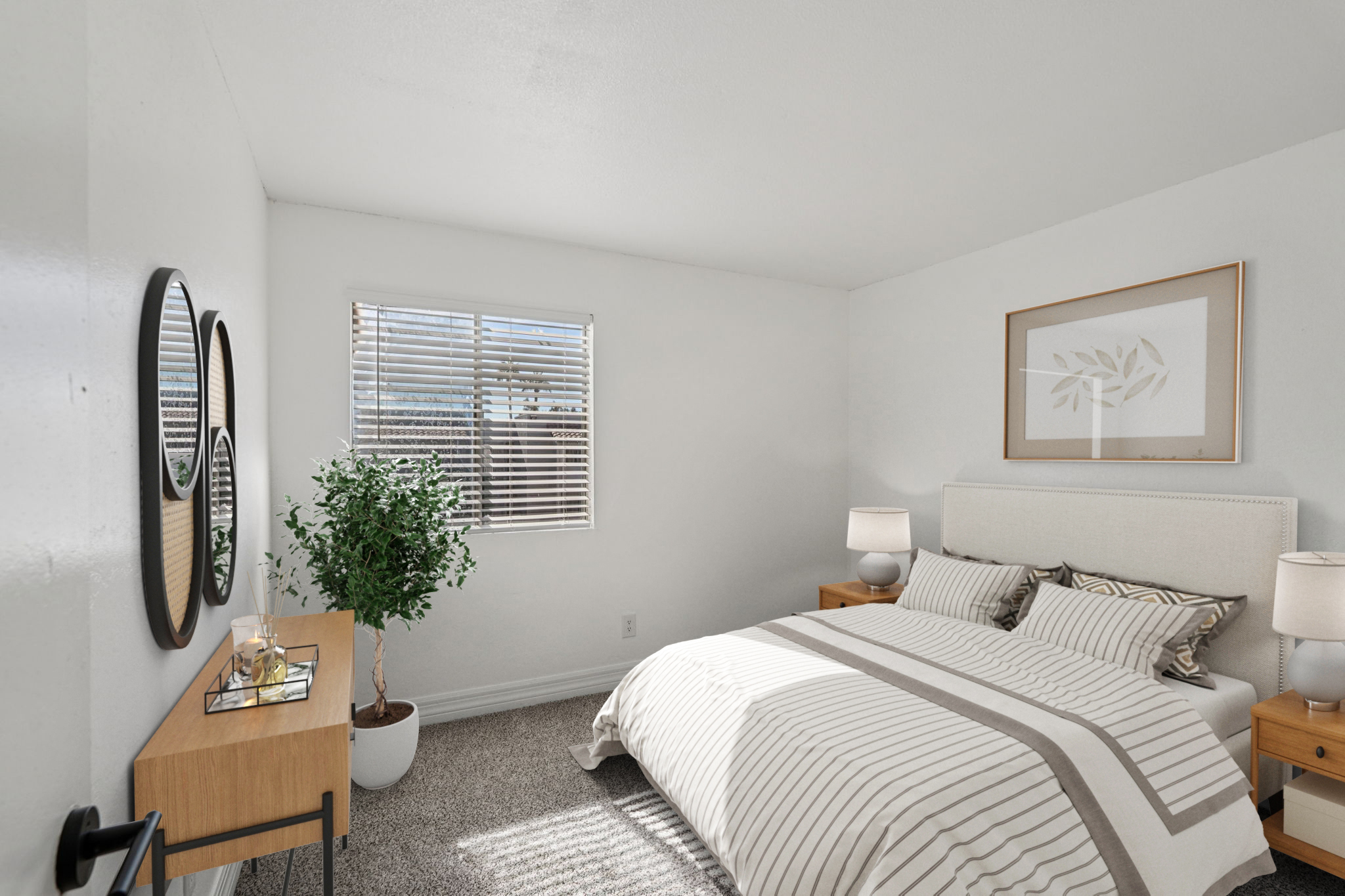 A cozy bedroom featuring a queen-sized bed with striped bedding, two bedside tables with lamps, a small plant, and a framed artwork on the wall. Natural light streams through a window with blinds, illuminating the soft neutral tones of the room.