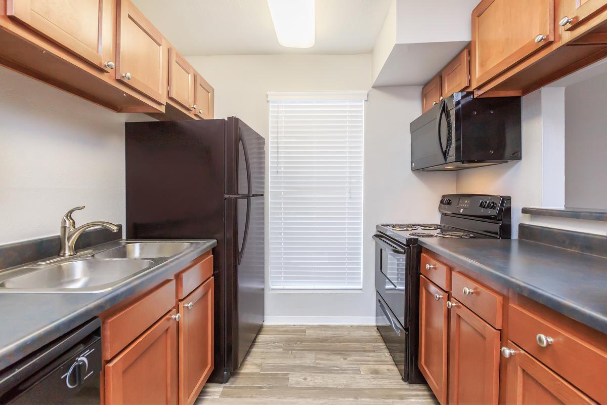 a large kitchen with stainless steel appliances and wooden cabinets