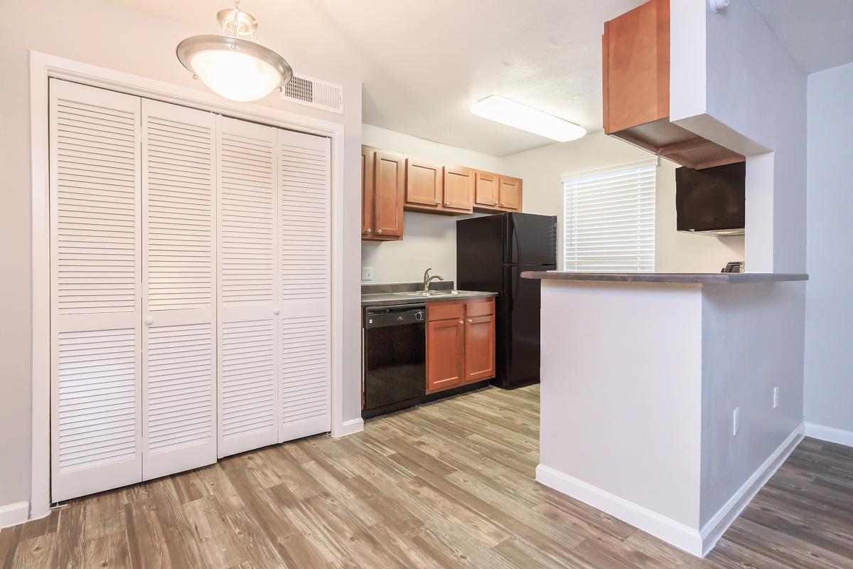 a kitchen with wooden cabinets and a refrigerator