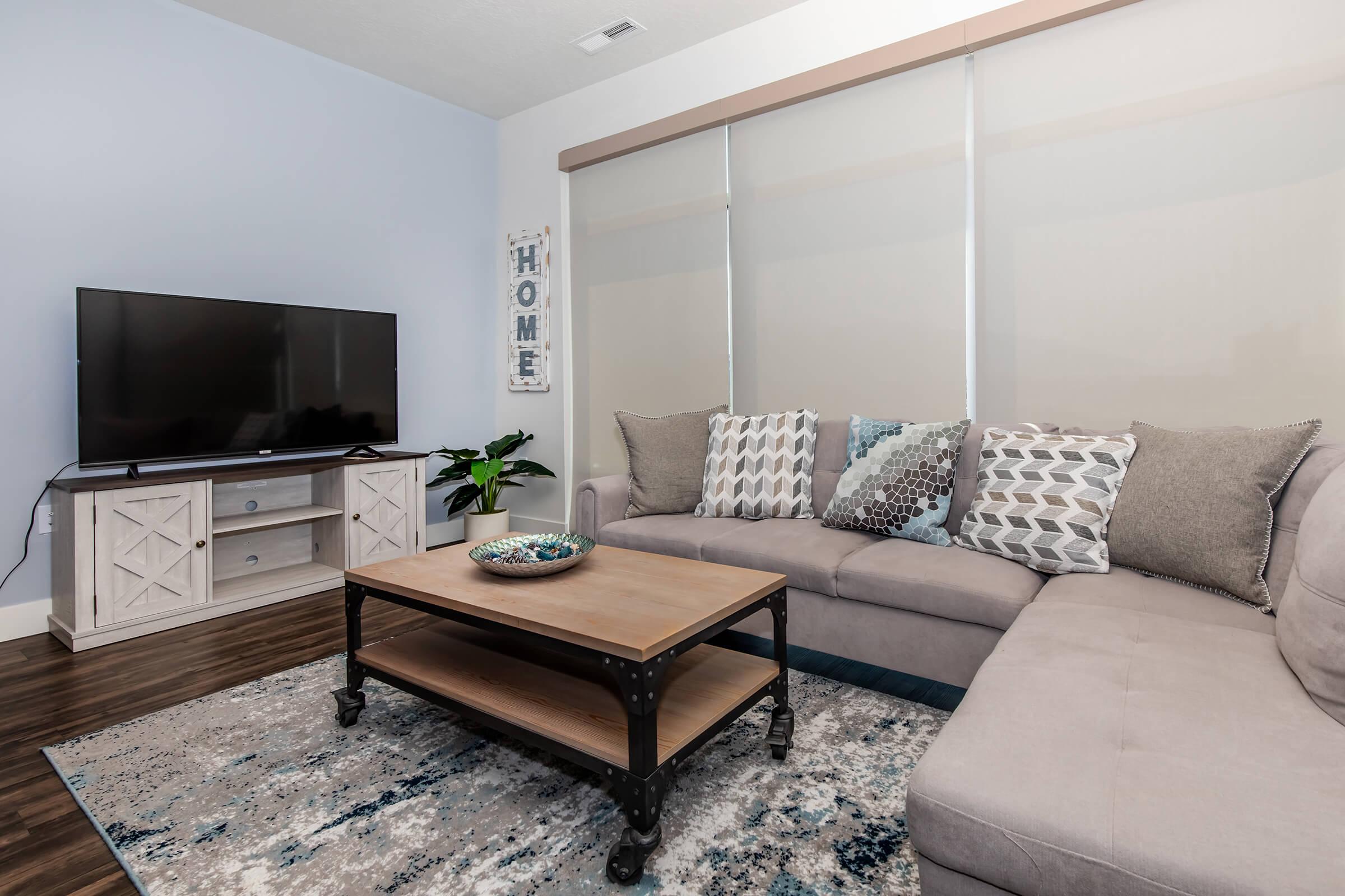 a living room filled with furniture and a flat screen tv