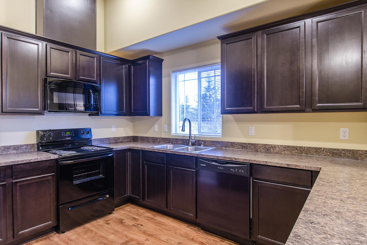 a large kitchen with stainless steel appliances and wooden cabinets