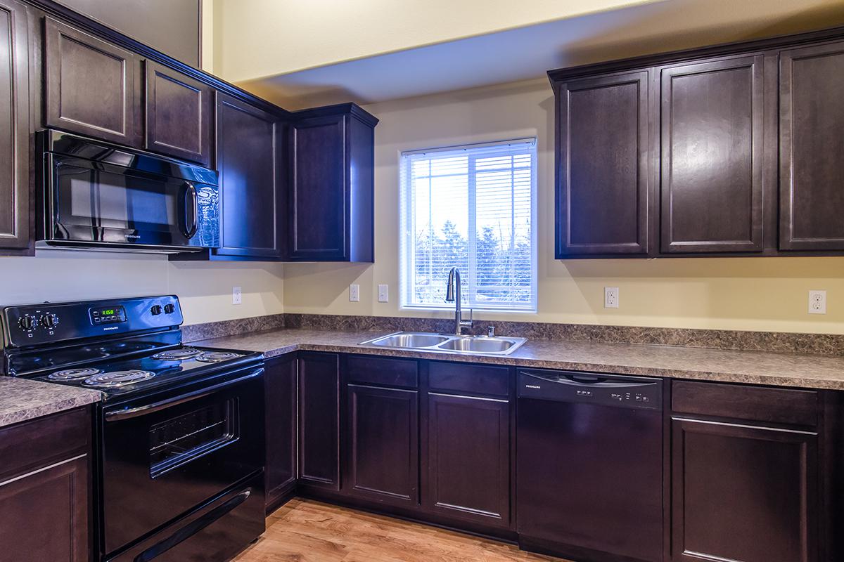 a large kitchen with stainless steel appliances and wooden cabinets