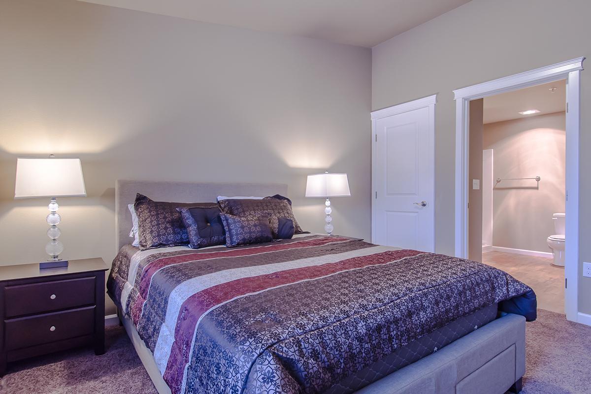 a bedroom with a bed and desk in a hotel room