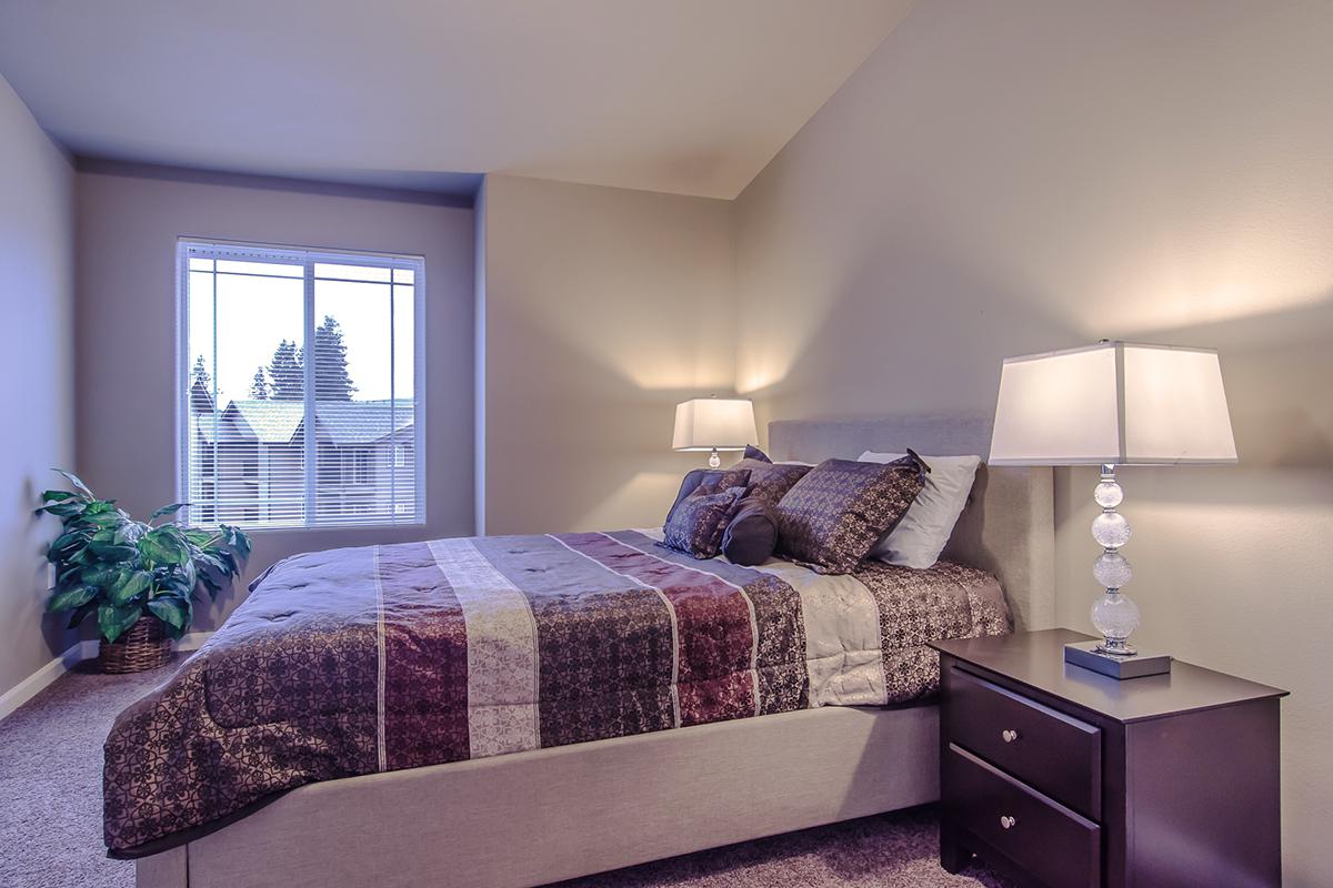 a bedroom with a bed and desk in a hotel room