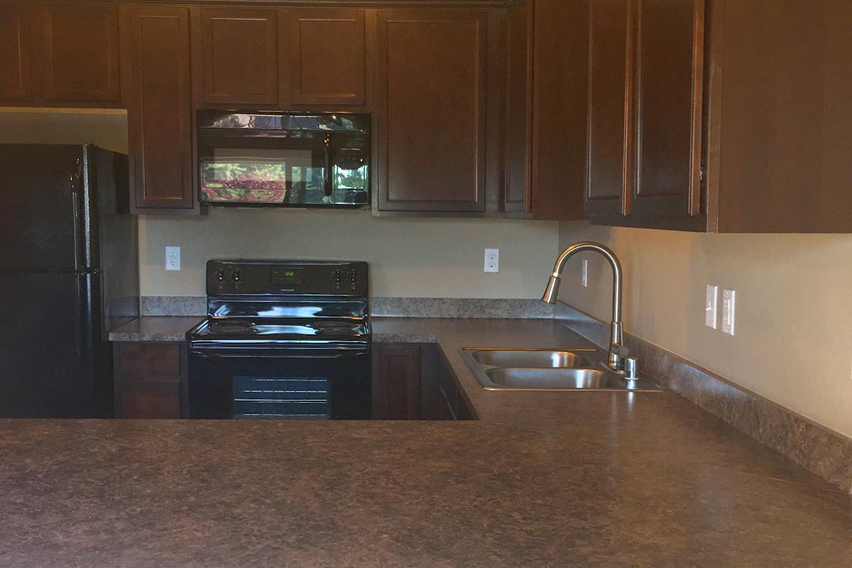 a kitchen with stainless steel appliances and wooden cabinets