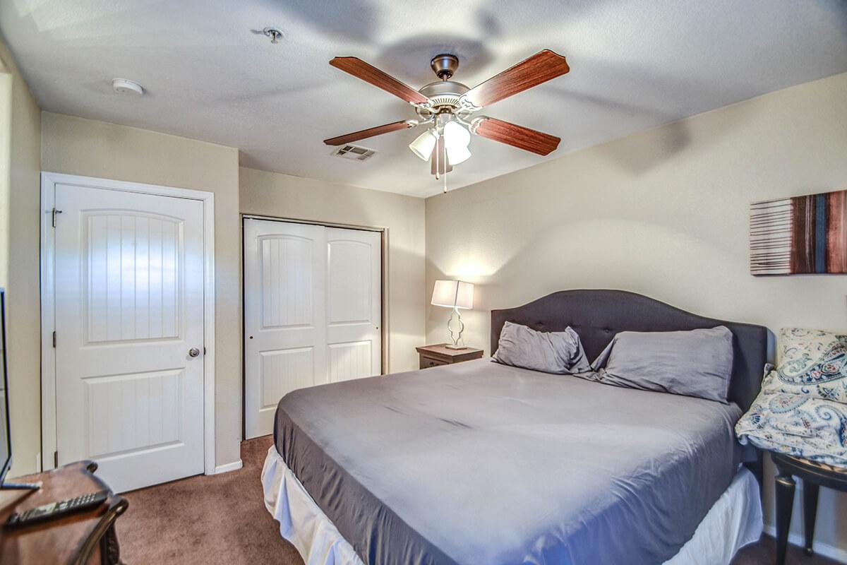 a bedroom with a bed and desk in a room