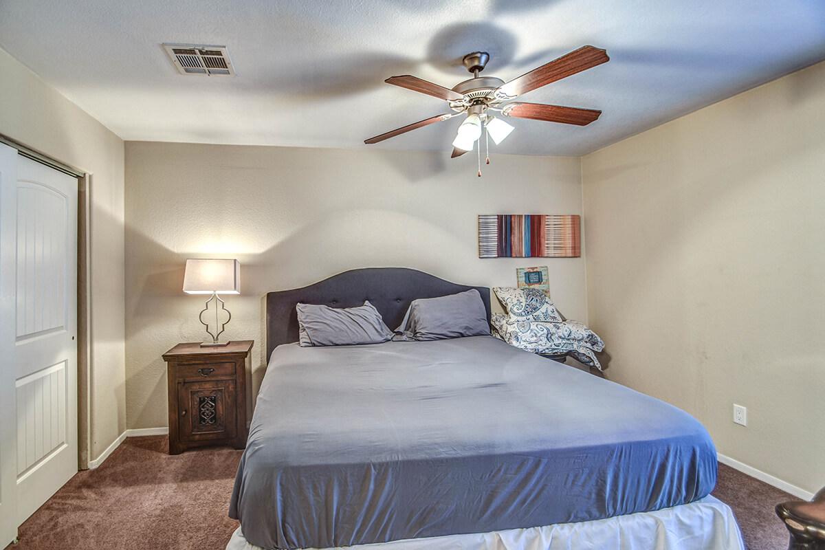 a bedroom with a bed and desk in a room