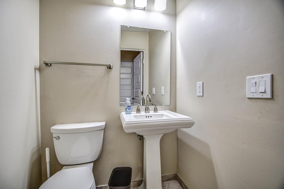 a white sink sitting under a mirror