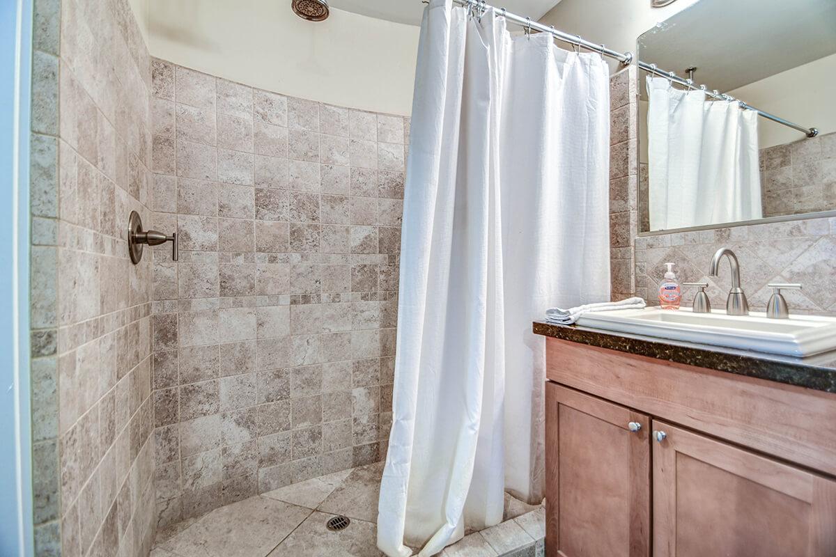 a white tub sitting next to a shower curtain