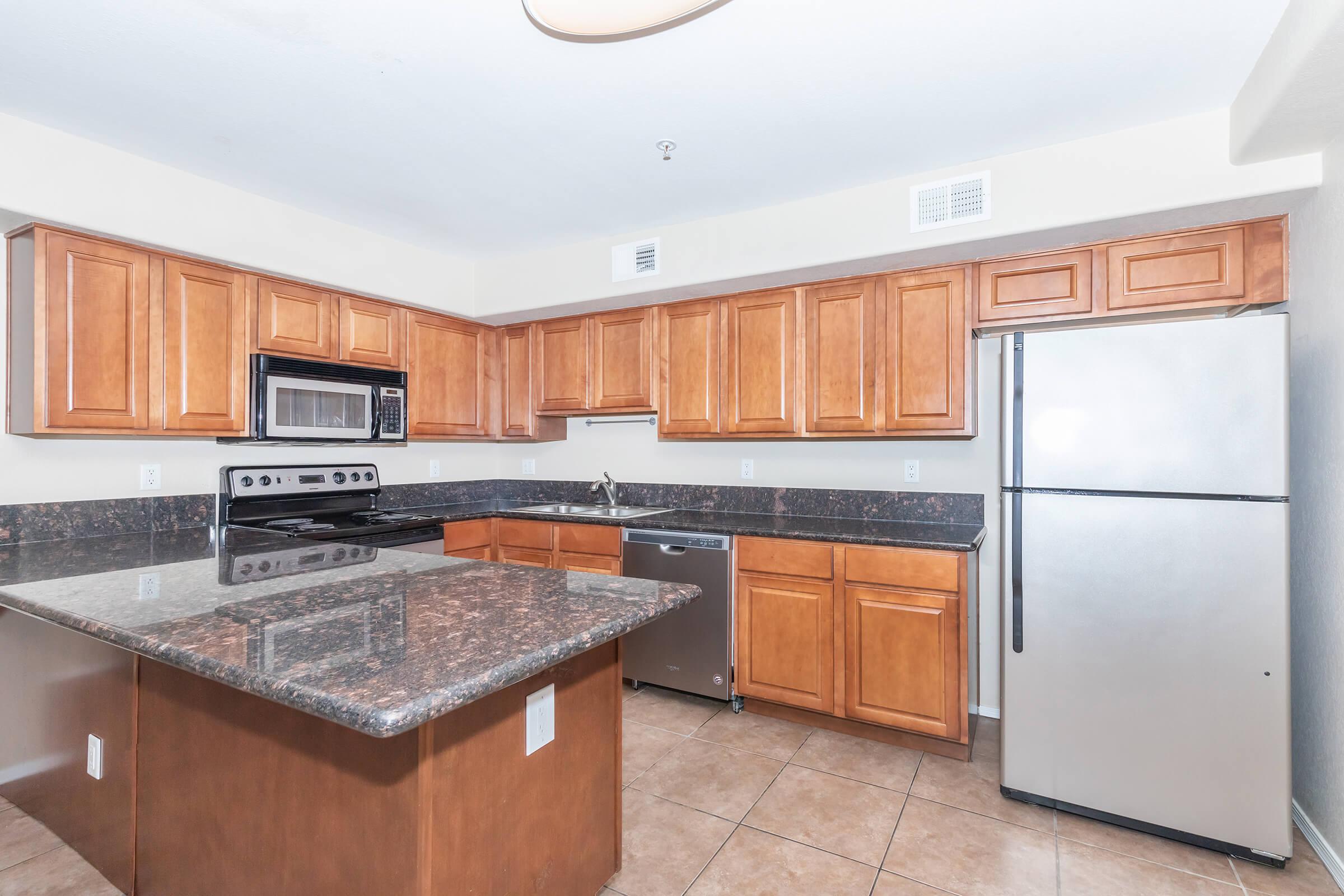 a large kitchen with stainless steel appliances and wooden cabinets