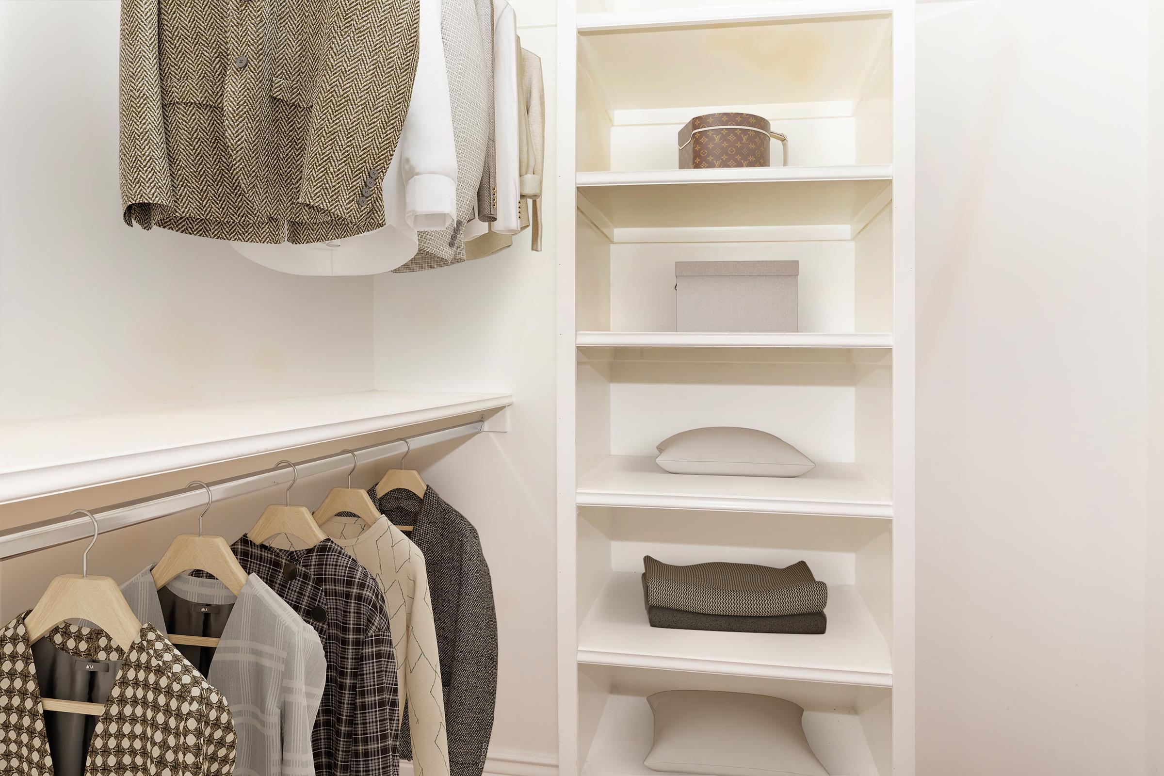 A neatly organized closet featuring a mix of hanging clothes including patterned shirts and blazers, along with shelves displaying neatly folded items and storage boxes. The closet has a clean, modern design with a light color palette.