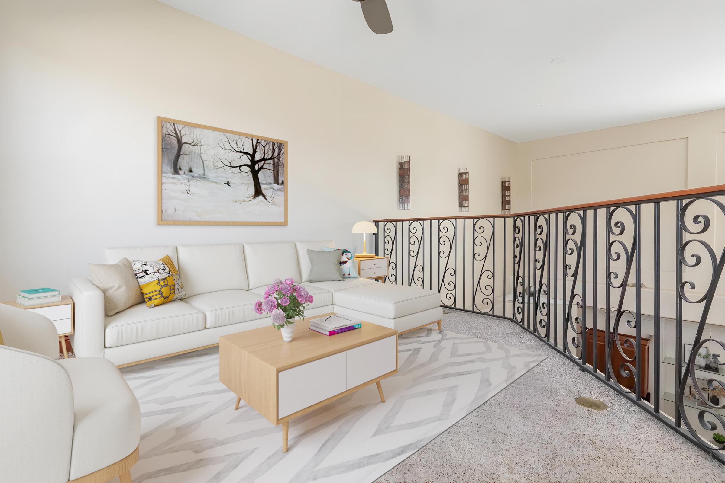 Bright and airy living space featuring a white sectional sofa with colorful cushions, a modern wooden coffee table, and a vase of fresh flowers. A large artwork depicting a winter scene hangs on the light-colored wall, while an elegant railing adds architectural interest. Soft lighting enhances the cozy atmosphere.