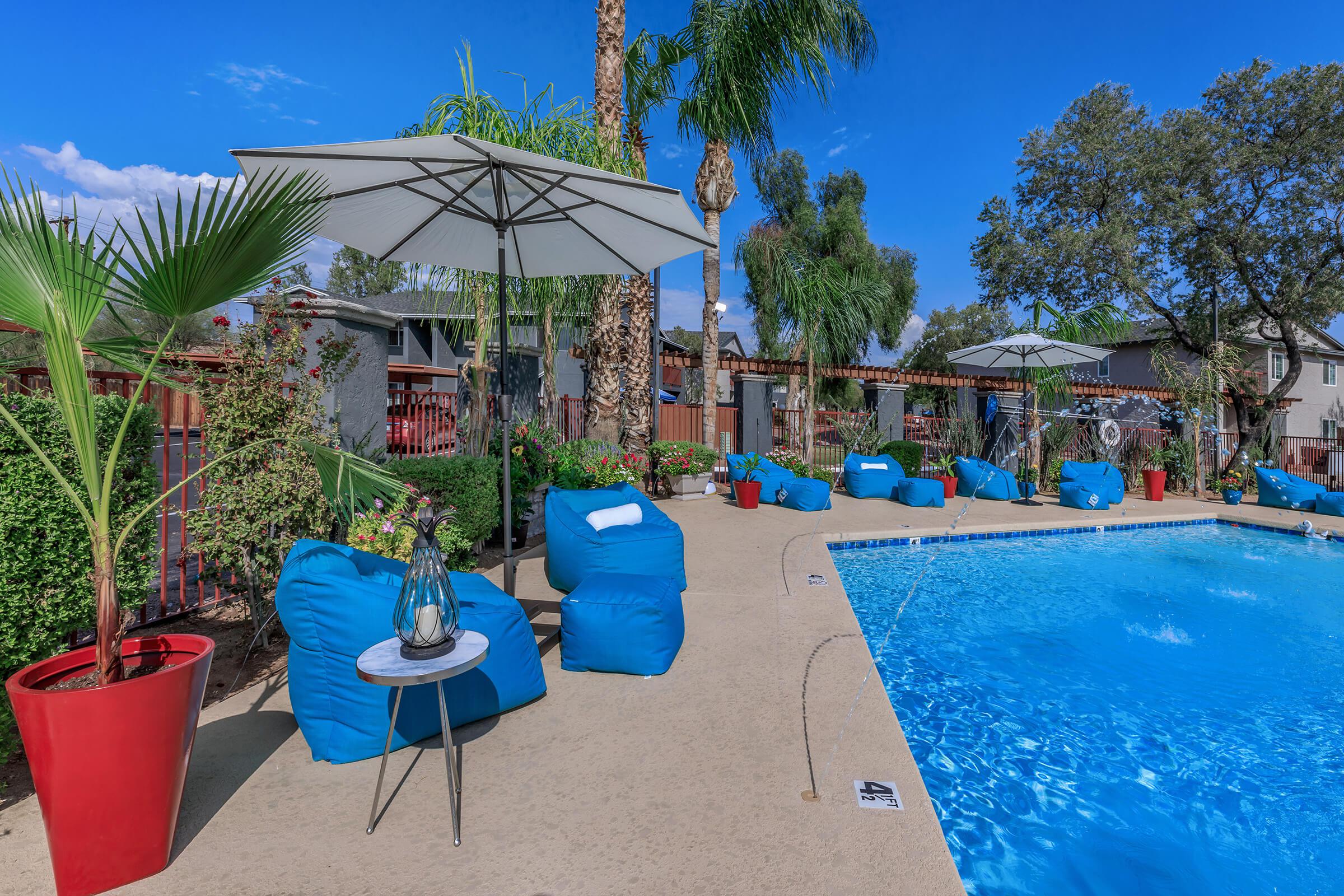 a group of palm trees with a blue umbrella