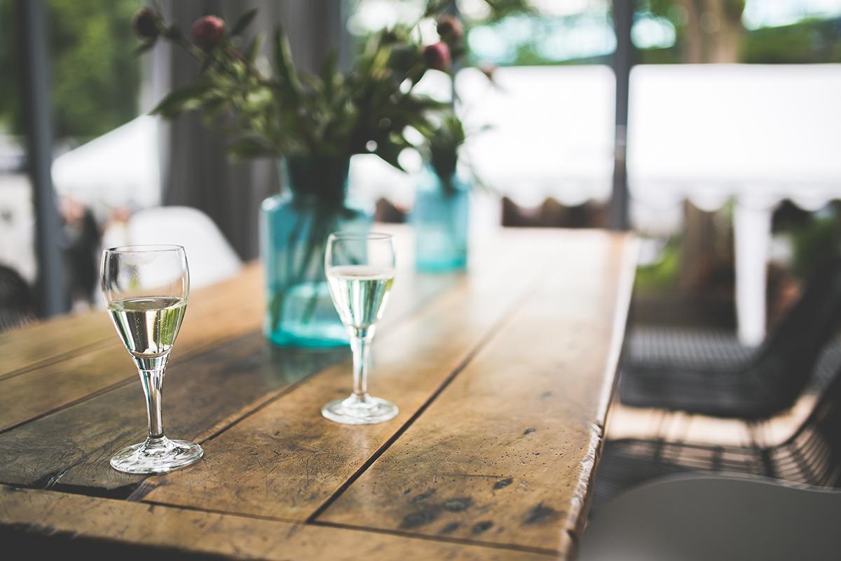 a glass of wine sitting on top of a wooden table