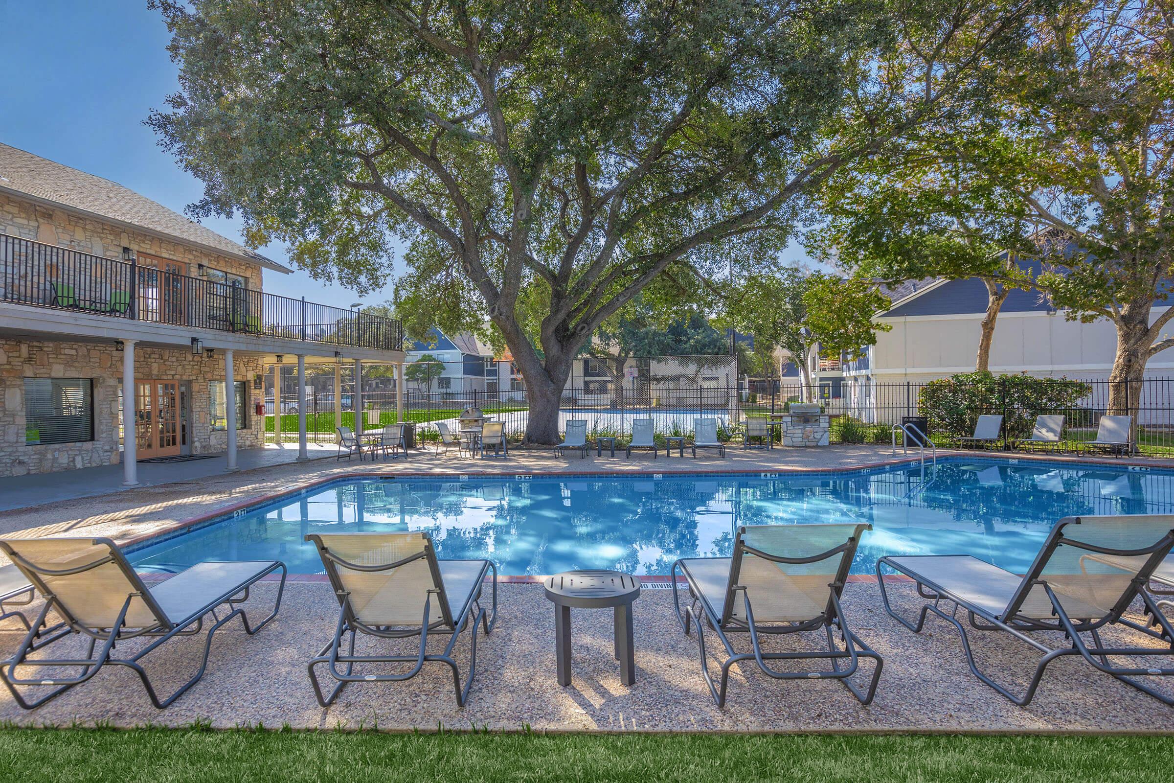 a group of lawn chairs sitting on a chair in front of a pool