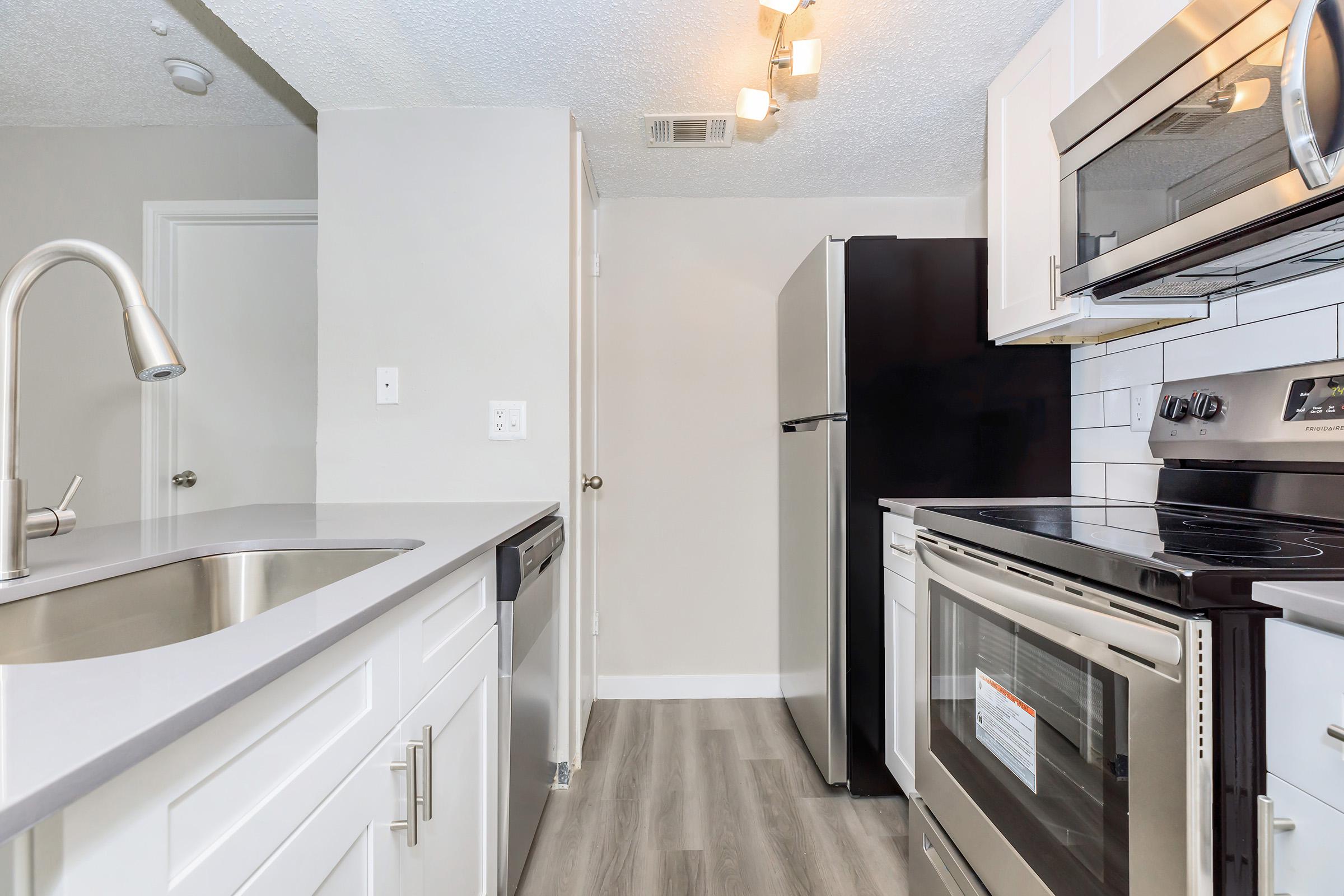 a kitchen with a stove sink and refrigerator