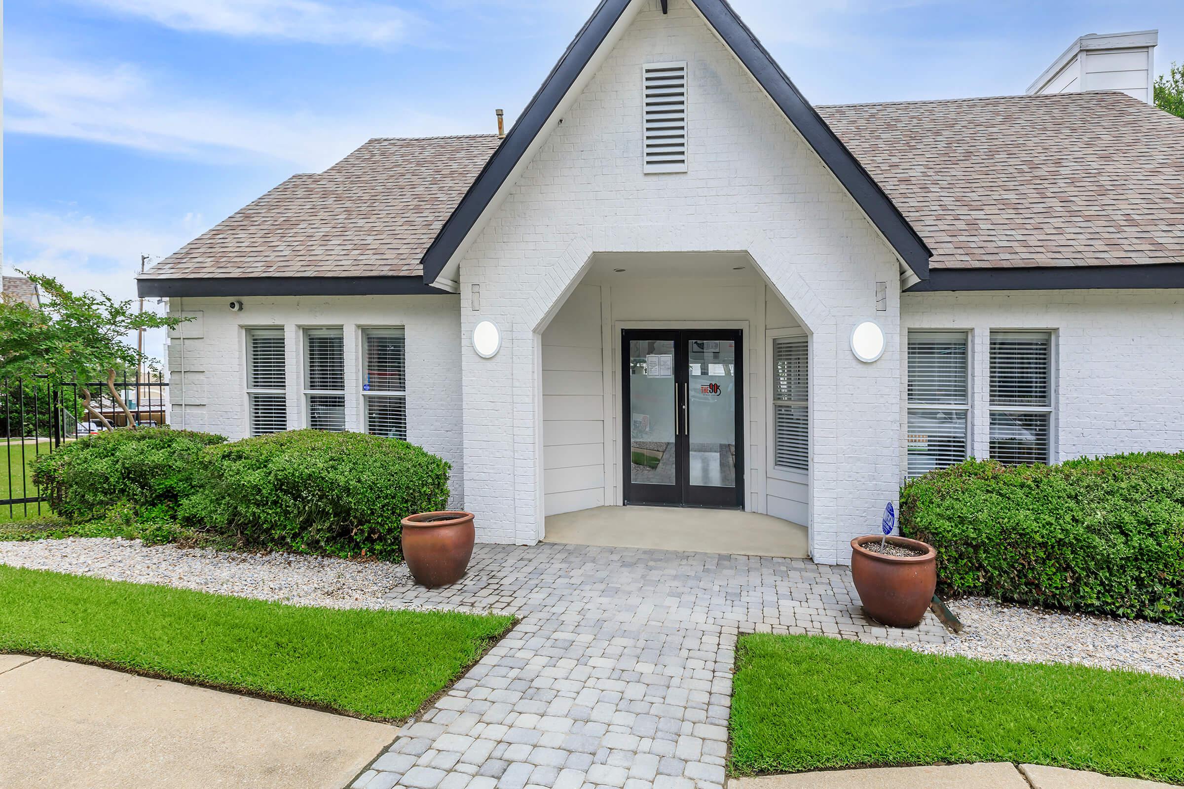 a large brick building with grass in front of a house