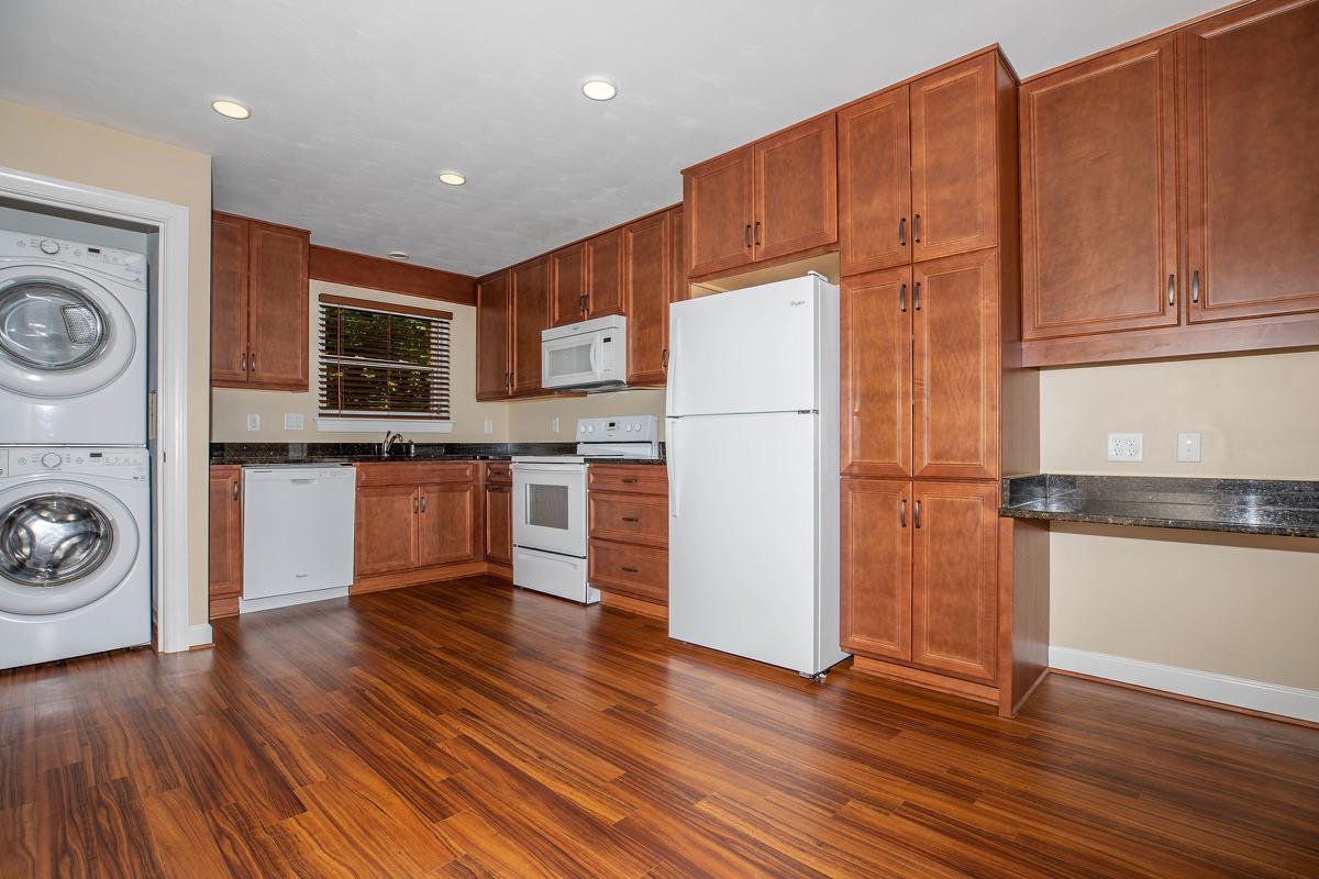 a large kitchen with stainless steel appliances and wooden cabinets