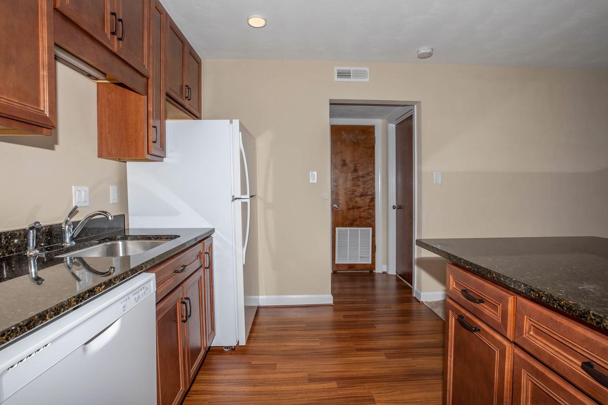 a large kitchen with stainless steel appliances and wooden cabinets