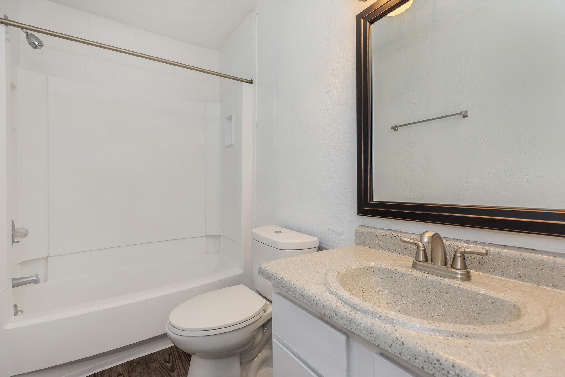 a white sink sitting under a mirror