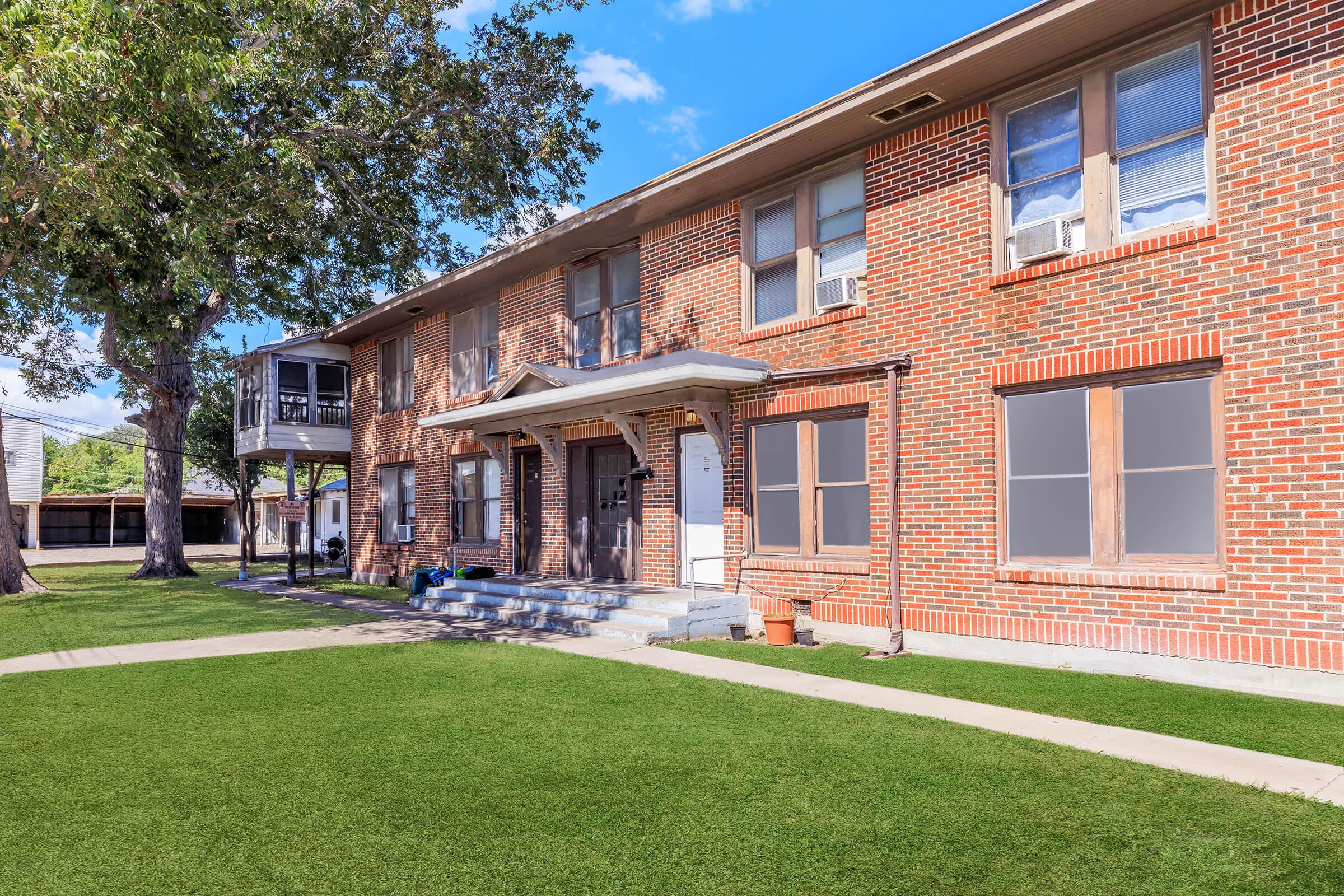 a large lawn in front of a brick building