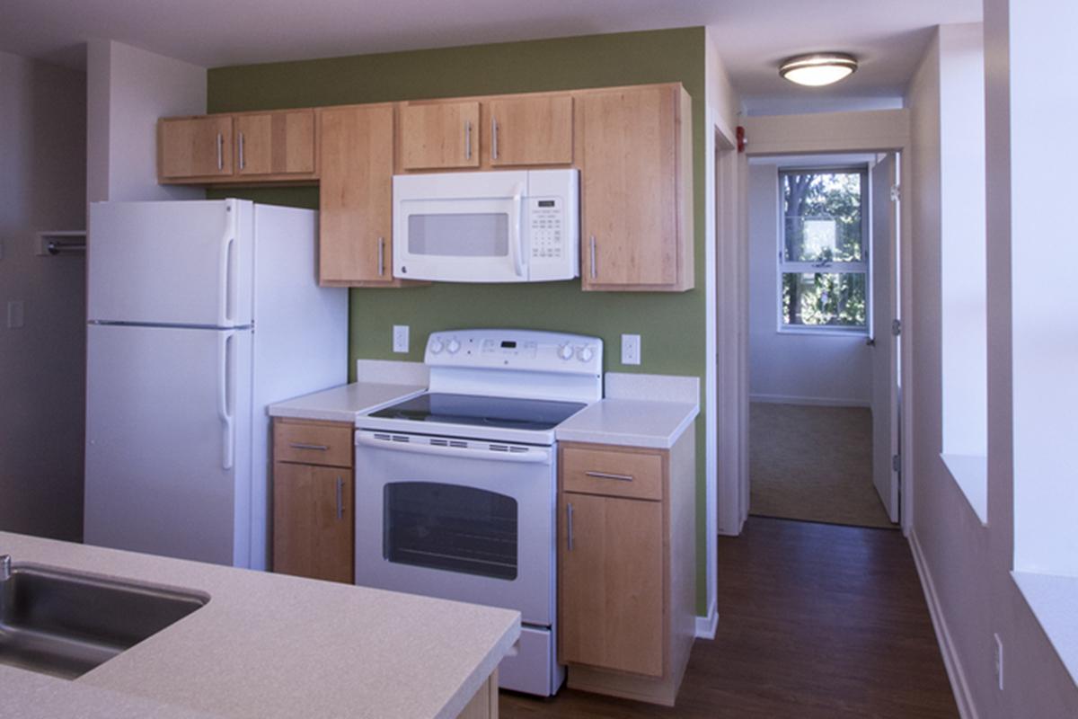 a kitchen with white appliances and wooden cabinets