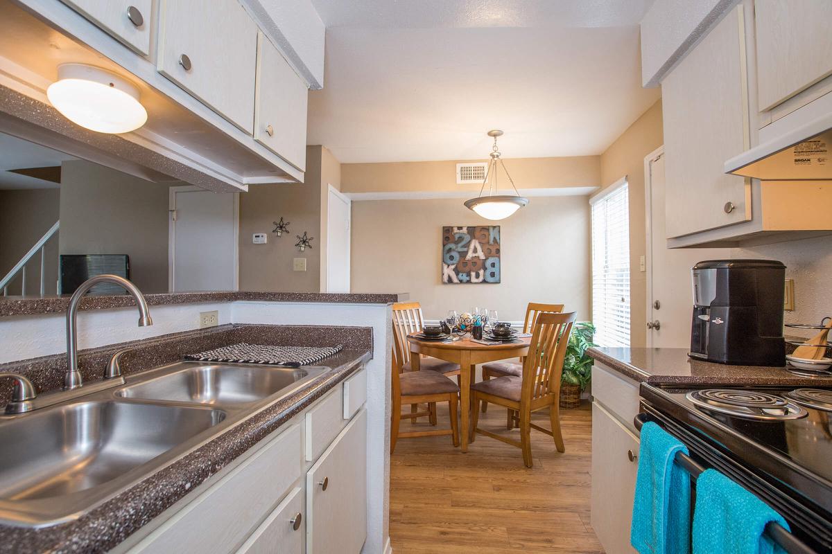 a large kitchen with stainless steel appliances and wooden cabinets