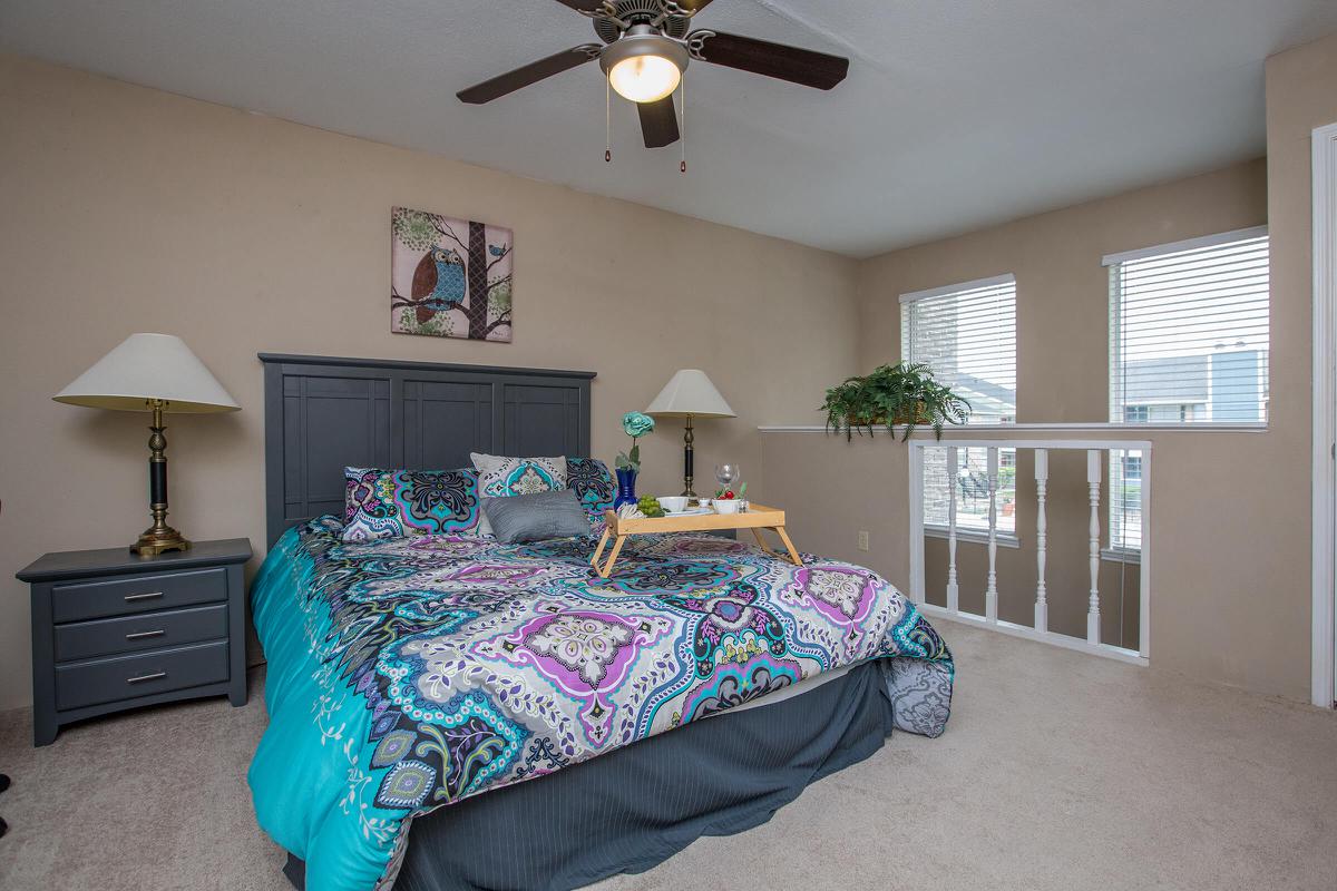 a bedroom with a bed and desk in a room