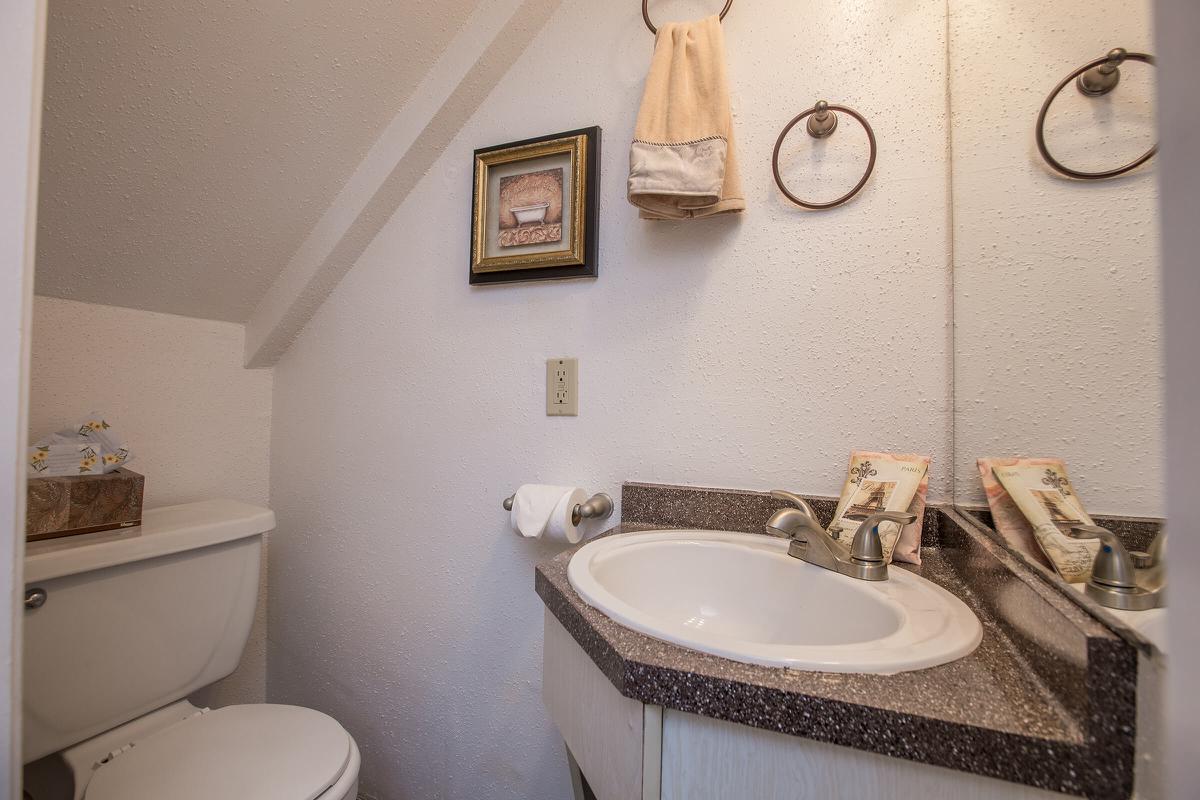 a white sink sitting under a mirror