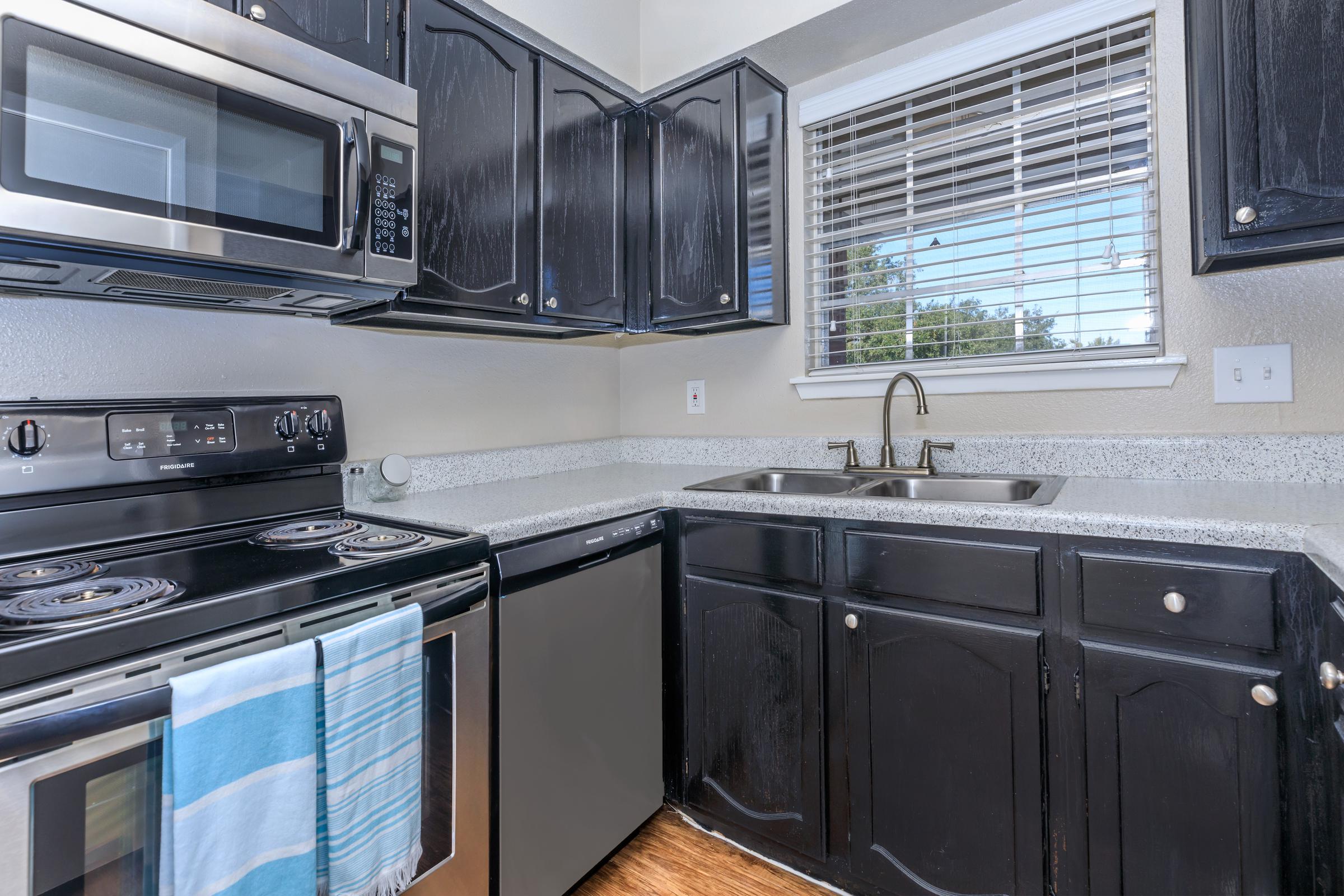 TWO INCH FAUX WOOD LOW LIGHT BLINDS IN KITCHEN