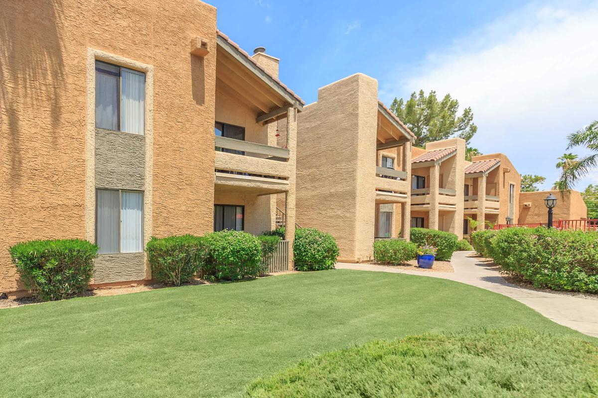 a large brick building with green grass in front of a house