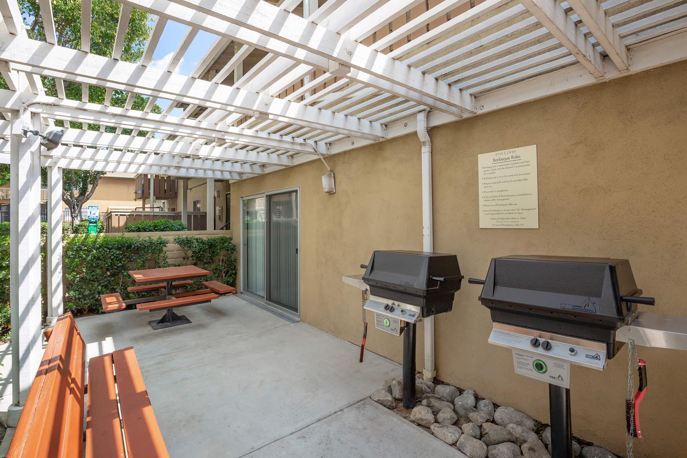 Barbecues and picnic tables under a pergola